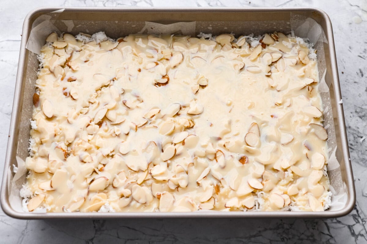 Sweetened condensed milk spread over the top of the almond layer. 