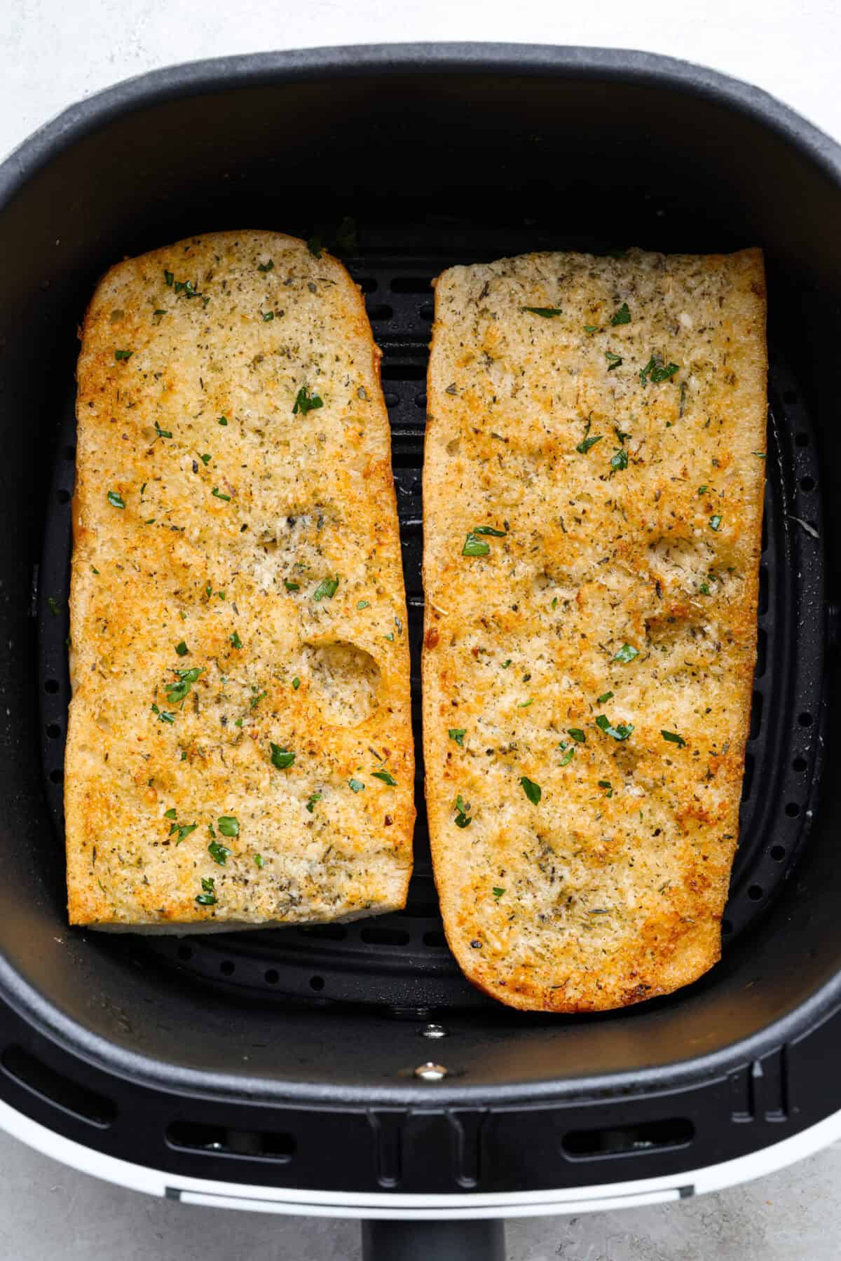 You all loved my best homemade garlic bread so much that an air fryer version was a must! It’s got the same buttery, garlicky magic, just quicker, crispier, and even easier. Overhead shot of air fryer garlic bread cooked and in the air fryer basket.