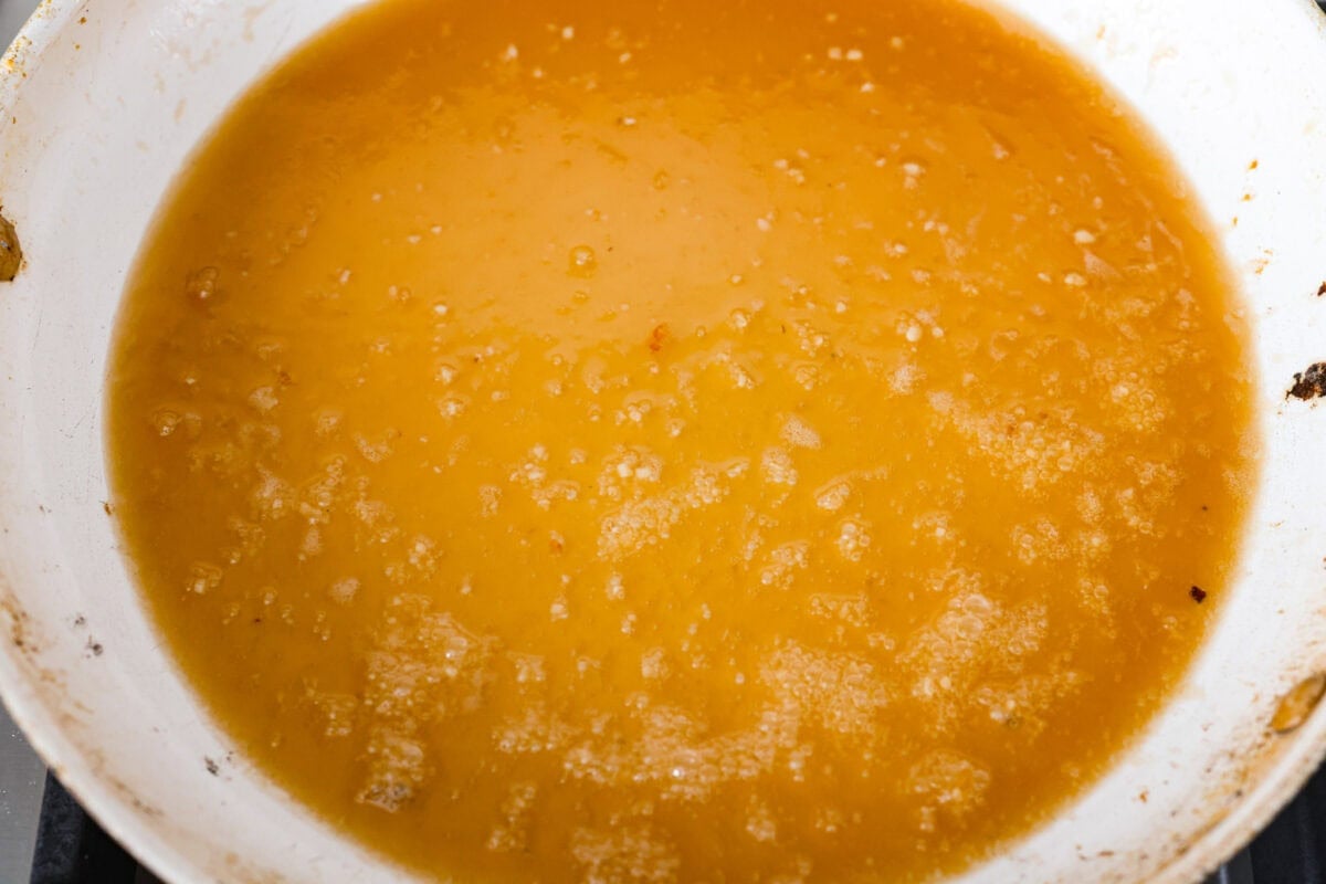 Sticky, sweet, and totally irresistible, this honey butter chicken brings golden brown perfection to your dinner table. One pan, picky-eater approved, and guaranteed to have everyone begging for seconds. Sauce ingredients simmering in the skillet.