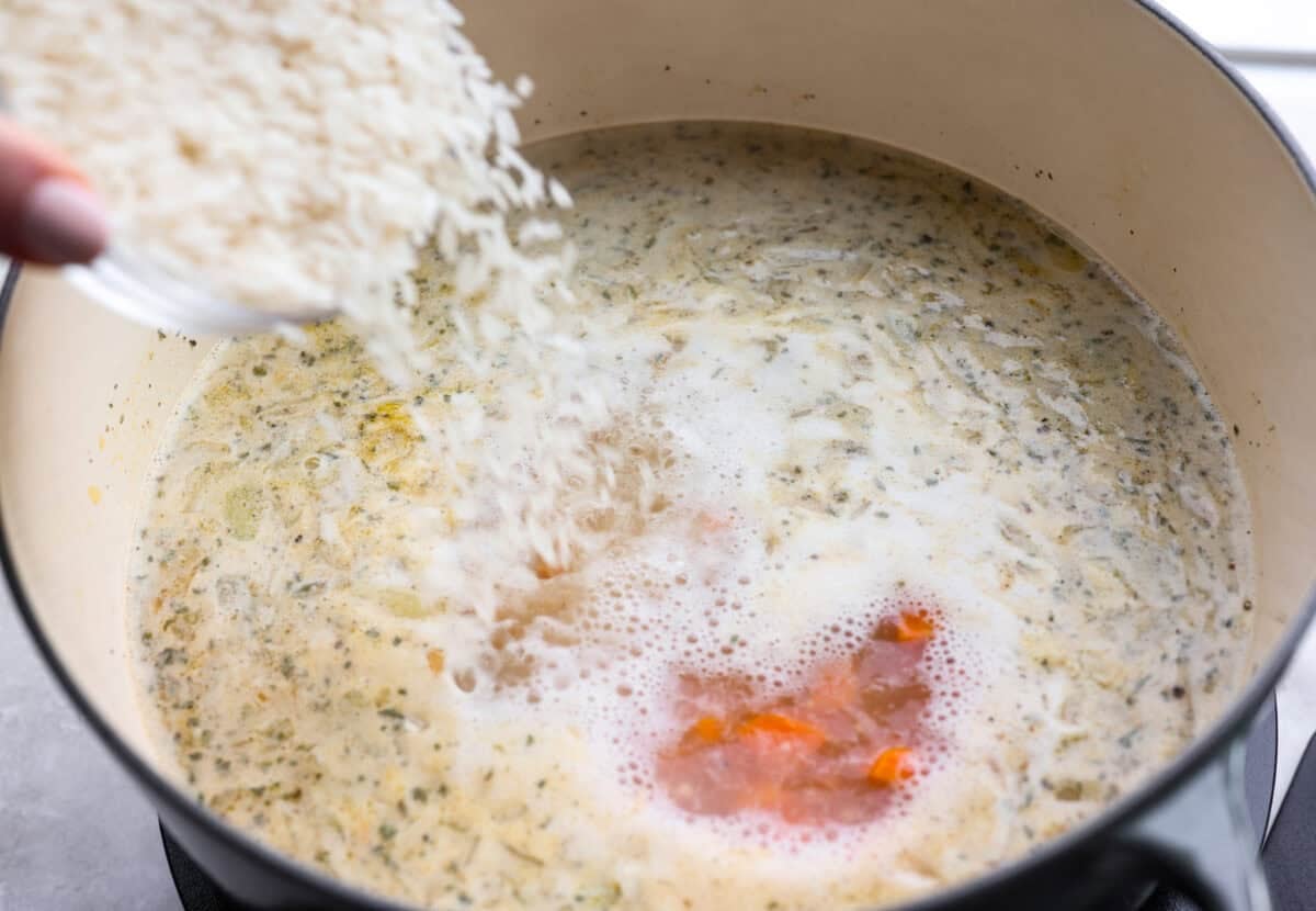 Someone pouring rice into the pot. 