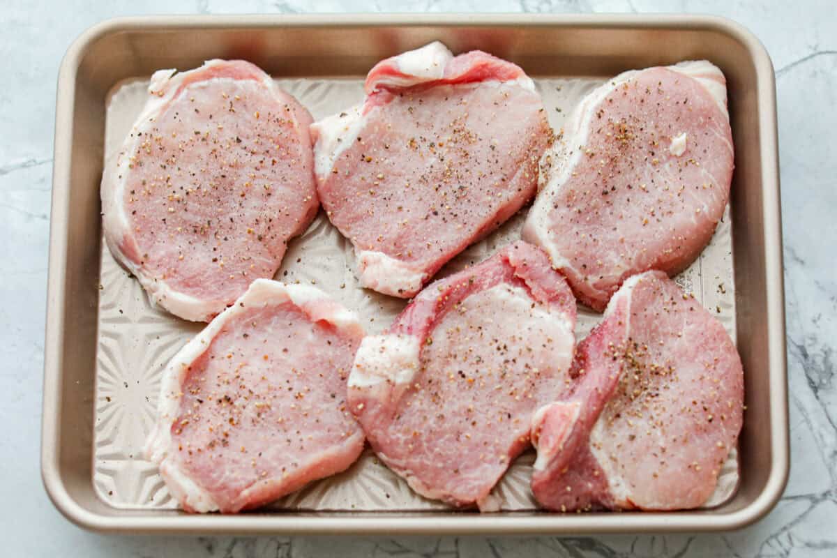 These honey mustard pork chops bring big flavor with very little effort. The whole grain mustard adds texture and bite, while a few extra spices deepen the sauce, turning a simple skillet dinner into something totally crave-worthy. Pork chops on a cookie sheet seasoned.