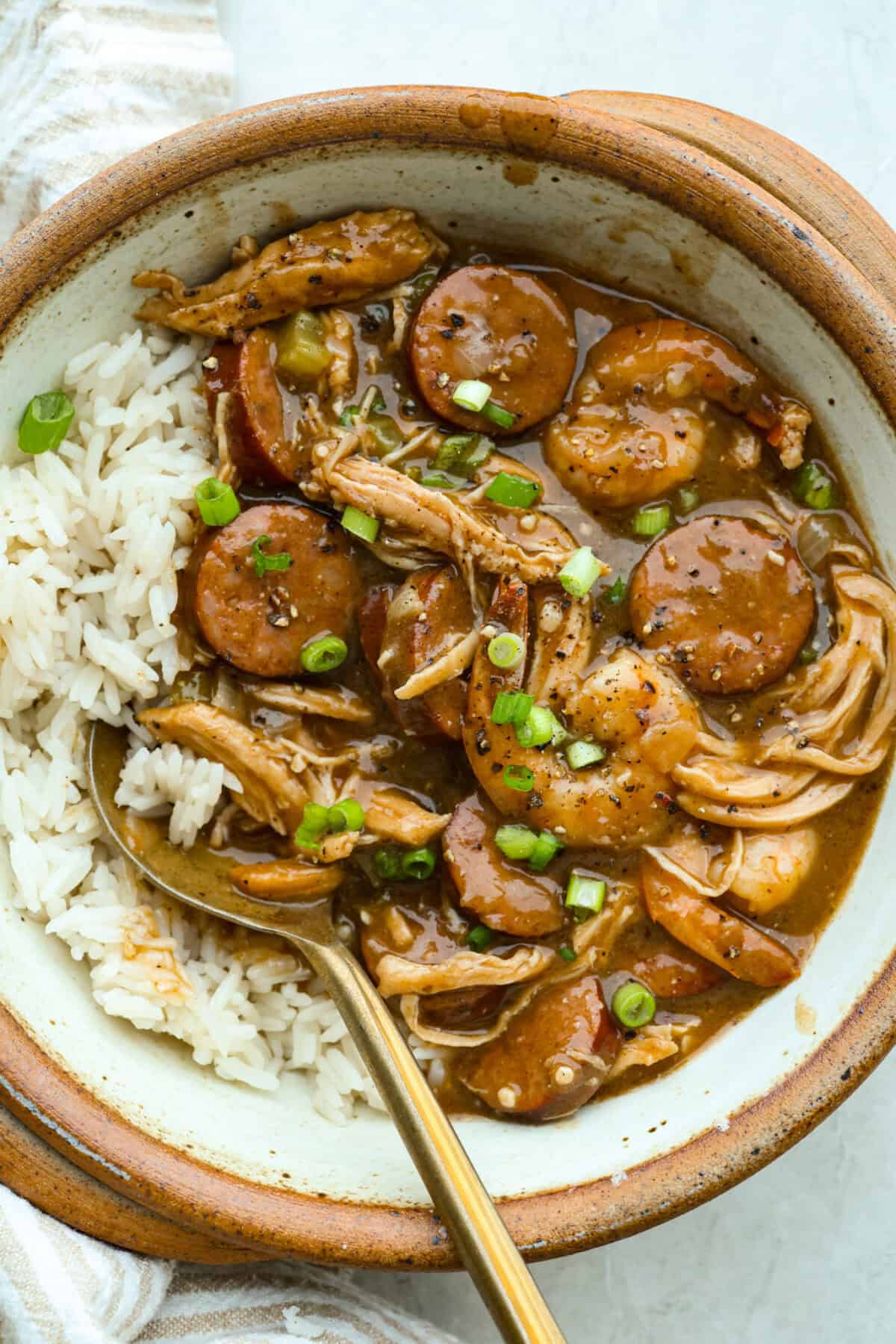 After listening to your feedback and learning what makes a great New Orleans gumbo, I made some changes. This version is richer, more balanced, and way closer to the real deal, without being overwhelming to make at home. Bowl of a serving of New Orleans gumbo with rice.