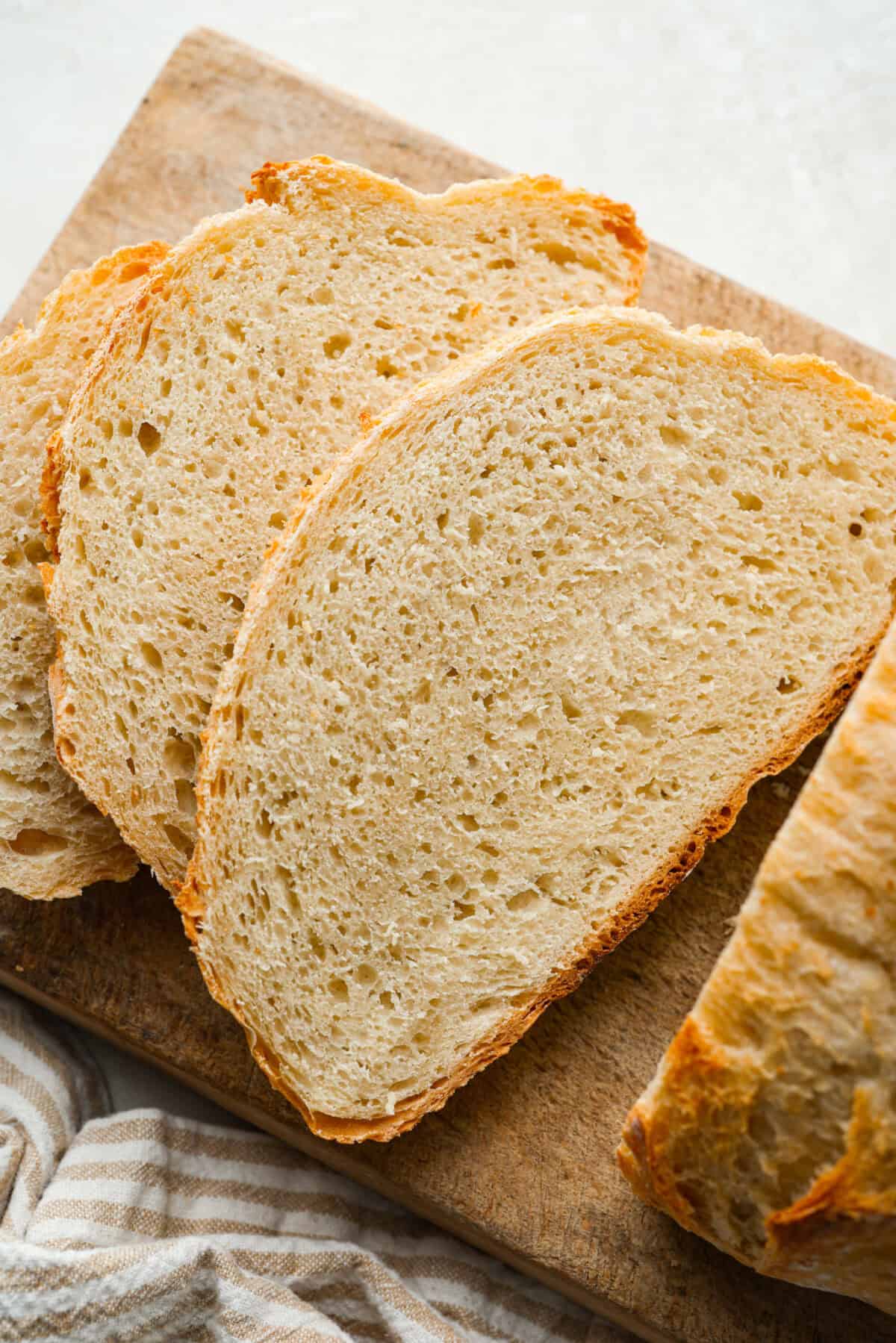 Myย 4-ingredient artisan breadย is simple, rustic, and completely bakery-worthy. With just flour, water, yeast, and salt, youโll get a loaf with a crusty outside and a soft, chewy center. Artisan bread sliced on a cutting board.