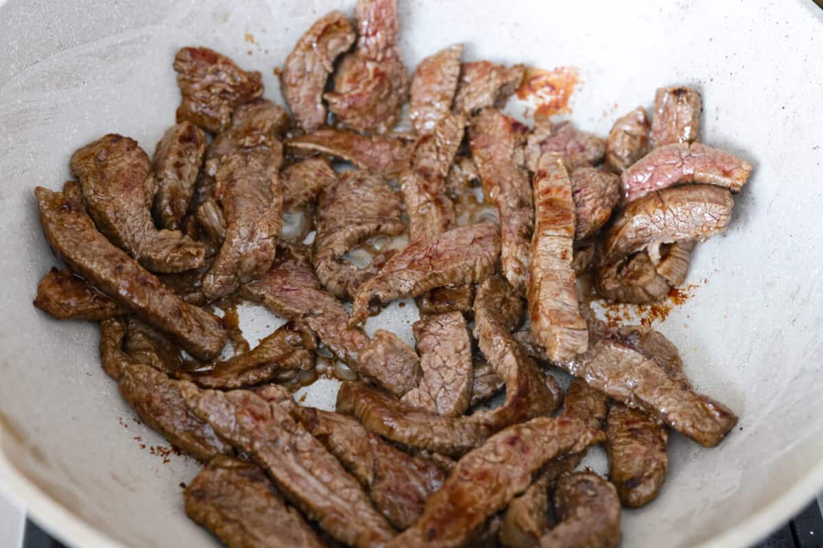 Strips of steak cooking in a wok. 