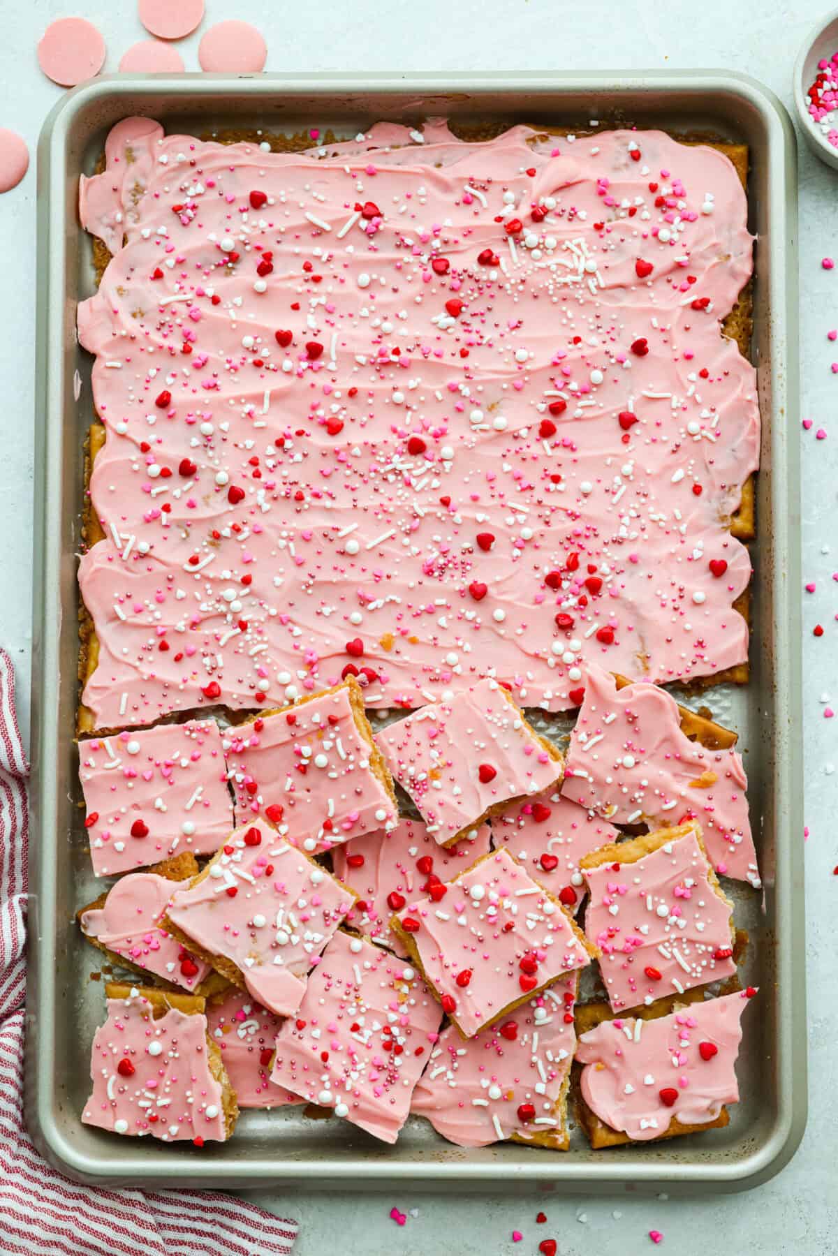 My Valentine’s Day Crack is the cutesy pink version of my famous Christmas crack! Same buttery, snappy toffee base, just with pink candy melts and festive sprinkles. It's perfect for kids' parties, Galentine's, or a sweet little Valentine's treat. Valentine's themed sprinkles added to the spread out melted candy melts and cooled so the crack can be cracked into pieces.