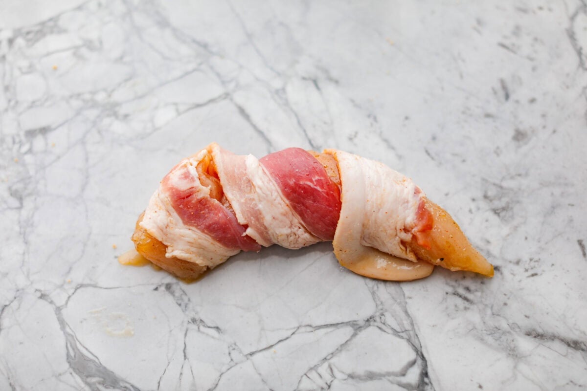 Slice of bacon wrapped around a brown sugar coated chicken tender. 