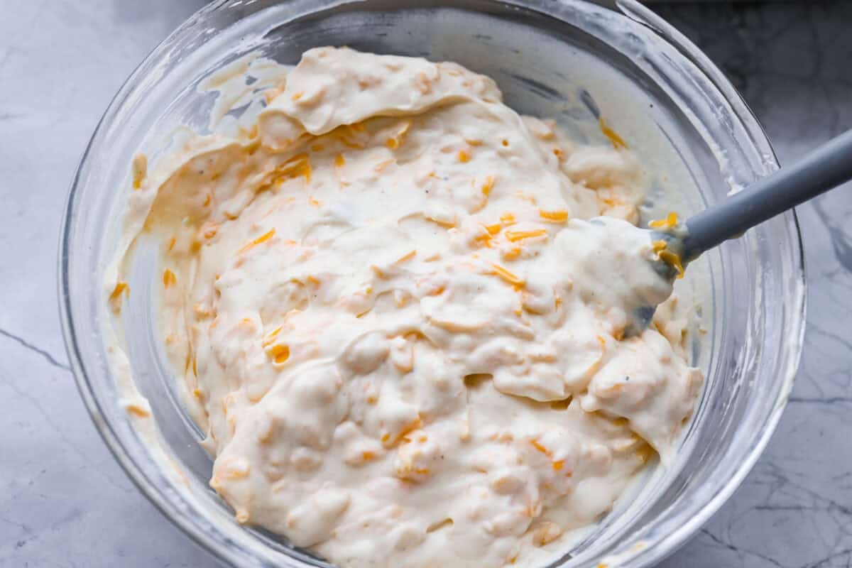 Chicken Divan is what I make when I want comfort food that still feels a little put-together. You get tender chicken, crisp-tender broccoli, and a creamy sauce bubbling under the most delicious golden, crunchy topping! Chicken divan sauce mixed together in a bowl.