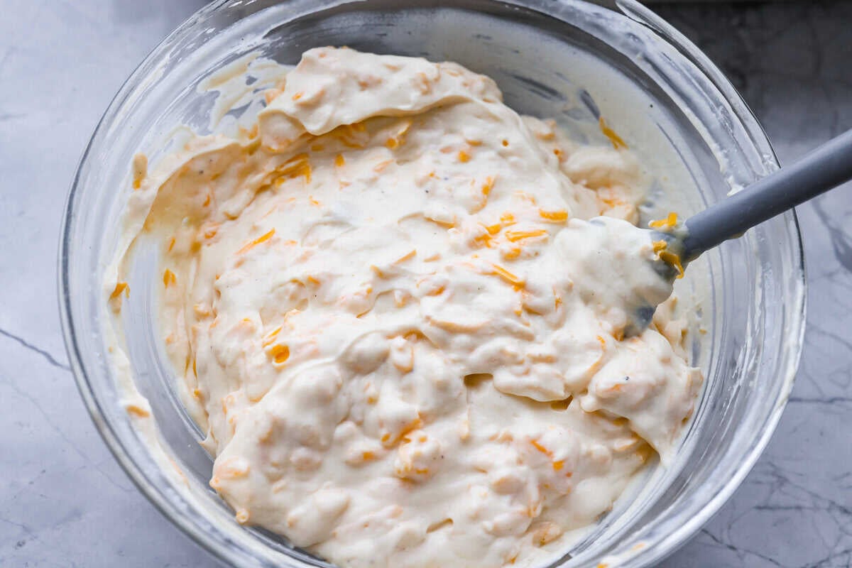 Chicken Divan is what I make when I want comfort food that still feels a little put-together. You get tender chicken, crisp-tender broccoli, and a creamy sauce bubbling under the most delicious golden, crunchy topping! Chicken divan sauce mixed together in a bowl.