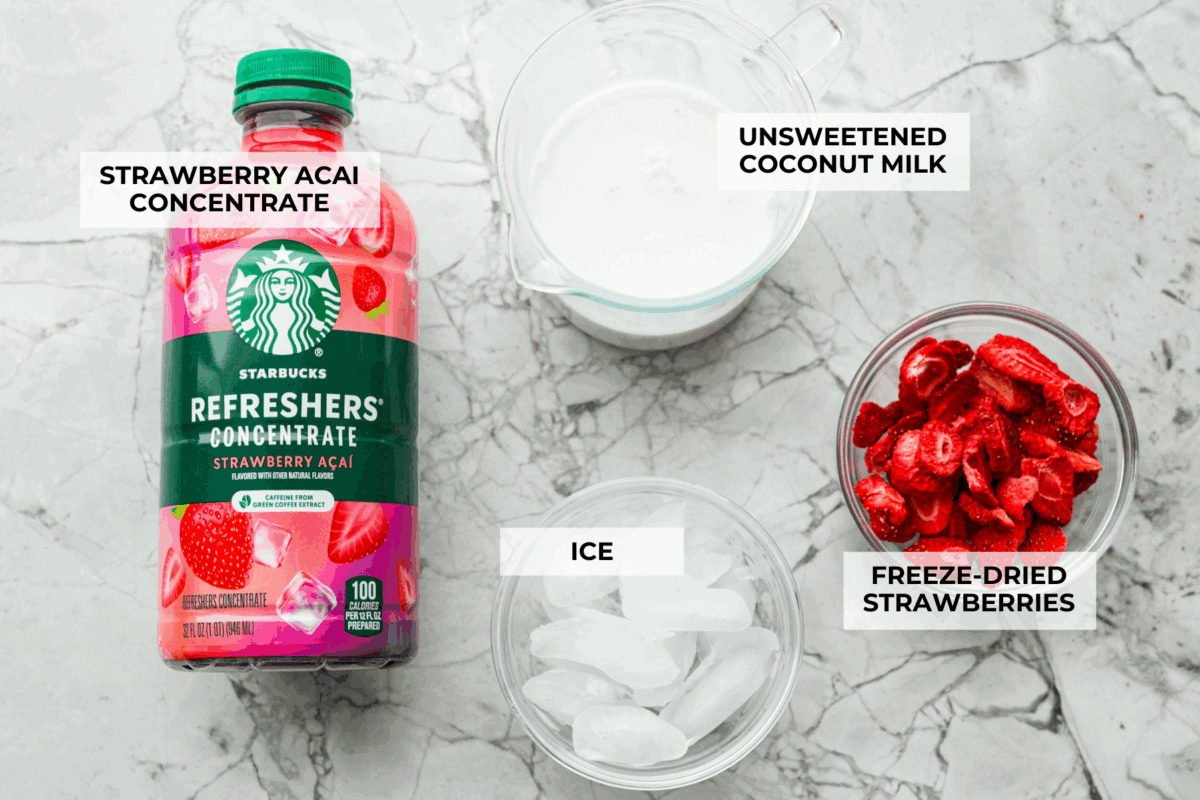 You guys, Starbucks sells the Strawberry Açaí concentrate in stores! Which means we can make the famous Starbuck's Pink Drink at home! And let me tell you, it's spot on! With just three ingredients, it's ridiculously easy to make year-round, and so good! Overhead shot of labeled ingredients.