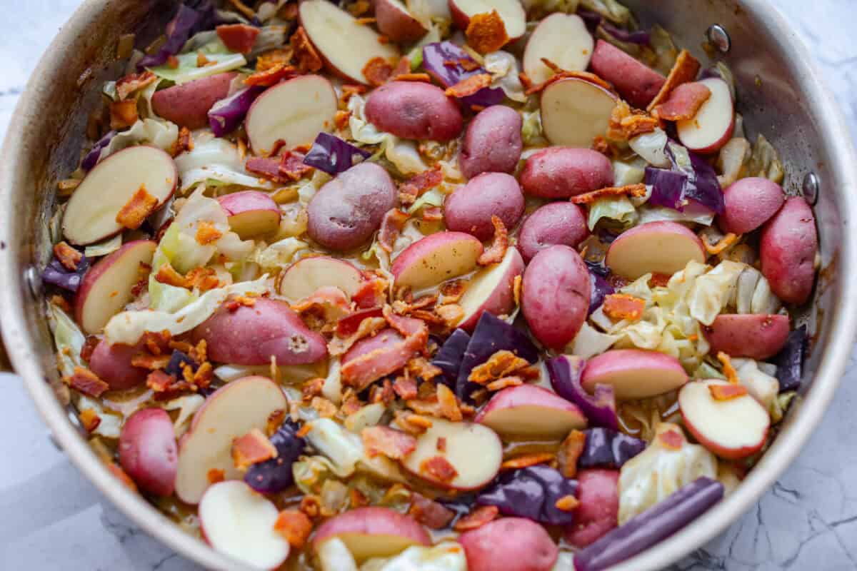 Potatoes and bacon added to the skillet. 