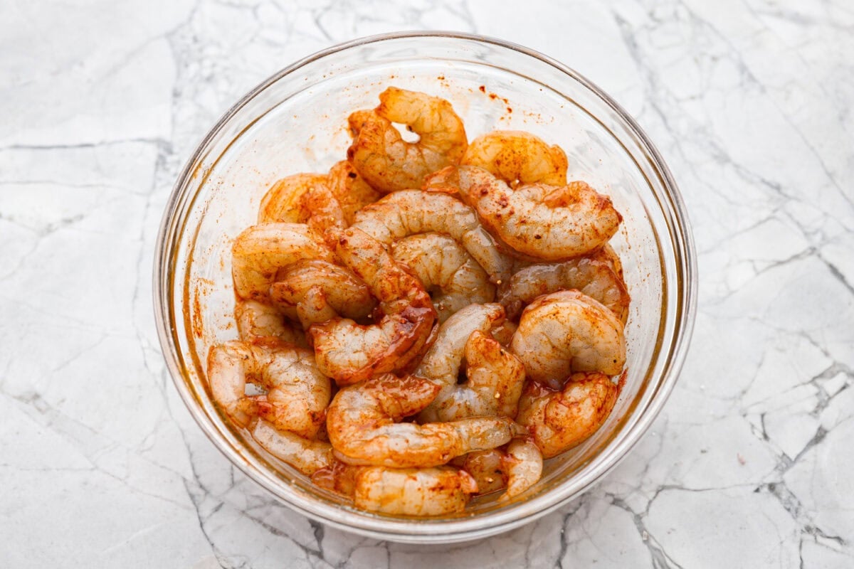 Bang bang shrimp pasta is what weeknight dinner dreams are made of! Juicy shrimp, tender pasta, and that irresistible sweet-and-spicy bang bang sauce come together in just 20 minutes. It’s creamy, bold, and guaranteed to be a hit. Raw shrimp seasoned in a mixing bowll.