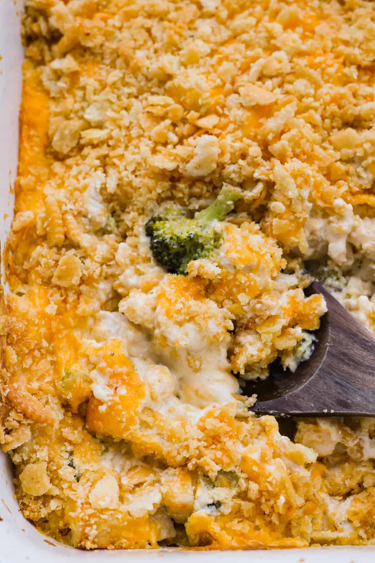 Chicken Divan is what I make when I want comfort food that still feels a little put-together. You get tender chicken, crisp-tender broccoli, and a creamy sauce bubbling under the most delicious golden, crunchy topping! Fully baked chicken divan casserole with a serving spoon taking a scoop.