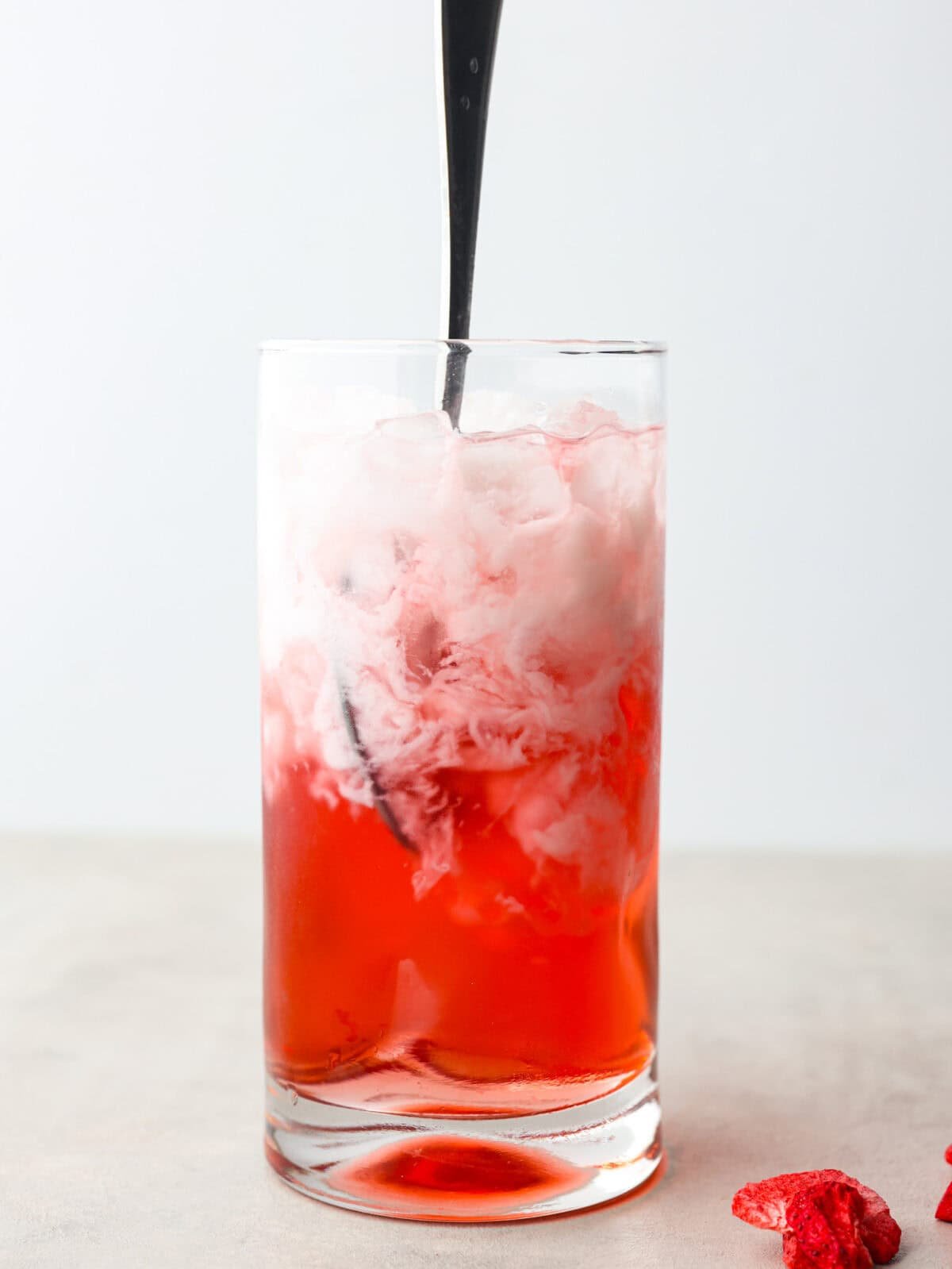 You guys, Starbucks sells the Strawberry Açaí concentrate in stores! Which means we can make the famous Starbuck's Pink Drink at home! And let me tell you, it's spot on! With just three ingredients, it's ridiculously easy to make year-round, and so good! Someone stirring the ingredients together.