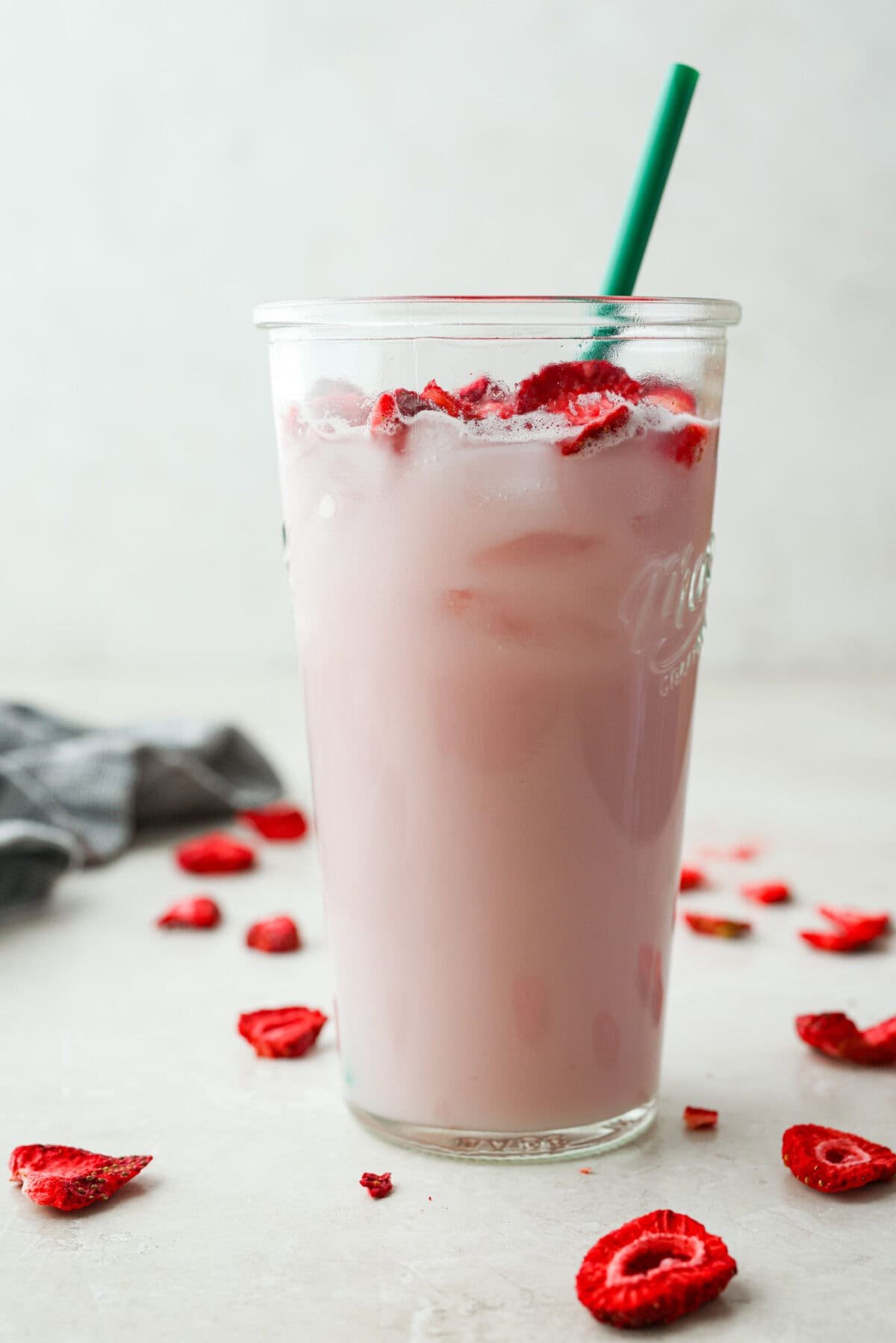 You guys, Starbucks sells the Strawberry Açaí concentrate in stores! Which means we can make the famous Starbuck's Pink Drink at home! And let me tell you, it's spot on! With just three ingredients, it's ridiculously easy to make year-round, and so good! Large glass with Starbucks copycat pink drink and green straw.