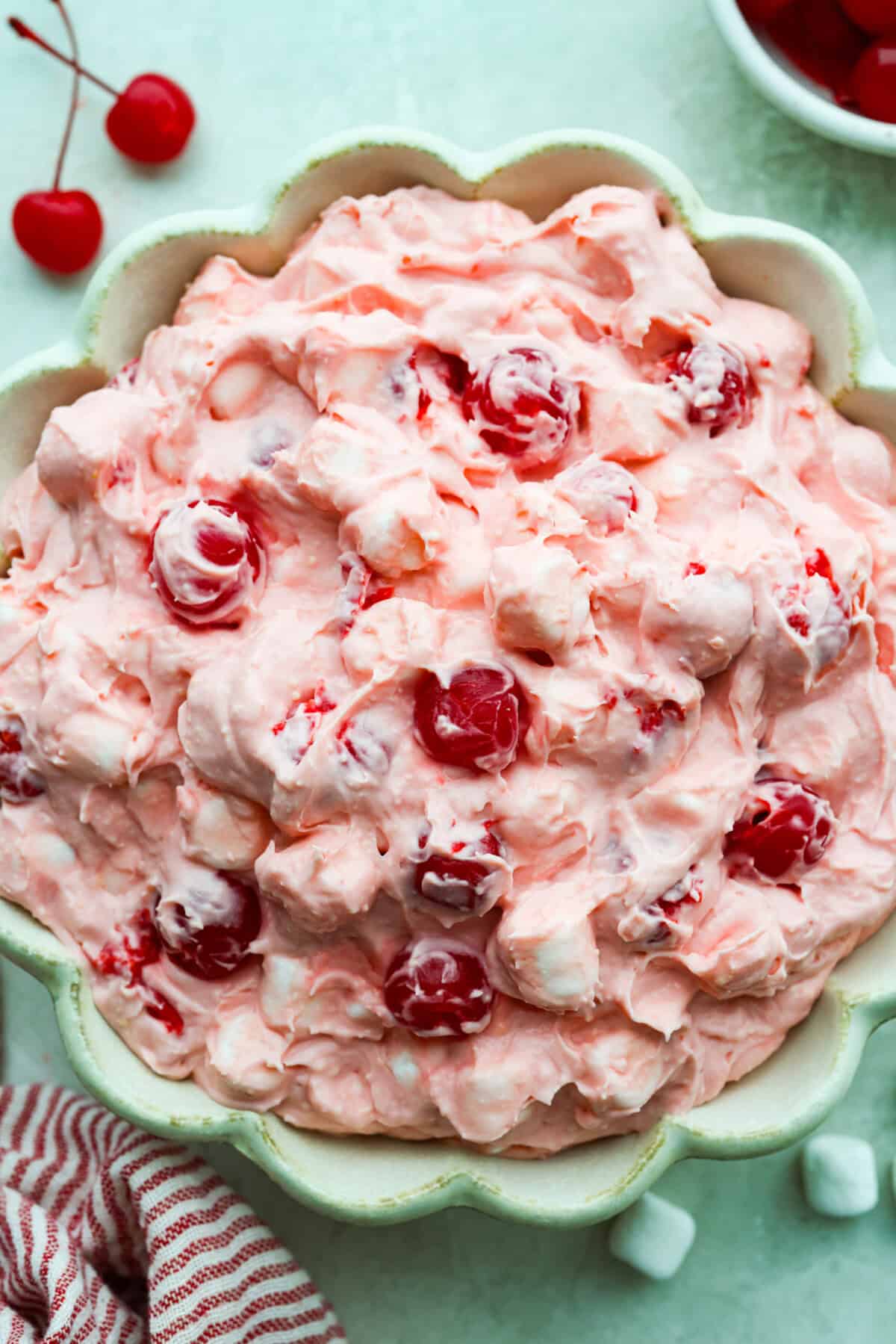 Fluff salads never go out of style. They're light, creamy, and just plain fun! This cherry cheesecake fluff is customizable and so easy to throw together! It's packed with sweet-tangy cheesecake flavor and juicy cherries in every bite. Large bowl of cherry cheesecake fluff.