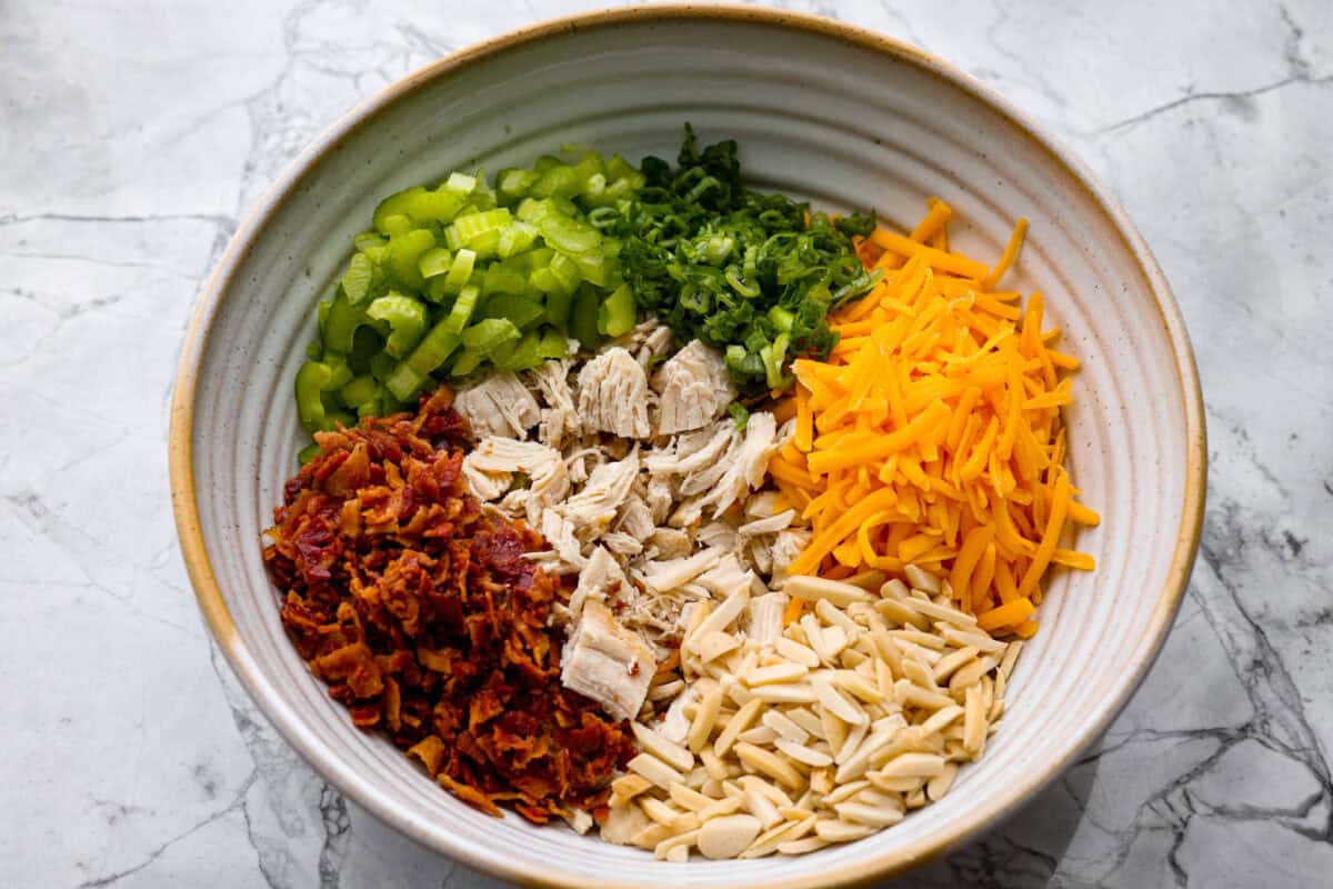 Million dollar chicken salad totally lives up to the name. It’s creamy, cheesy, crunchy, and packed with bacon, so every bite is full of flavor. Serve it on croissants, with crackers, or straight from the bowl! It's that good. Chicken, bacon, celery, green onions, cheese and almonds all added to a bowl.