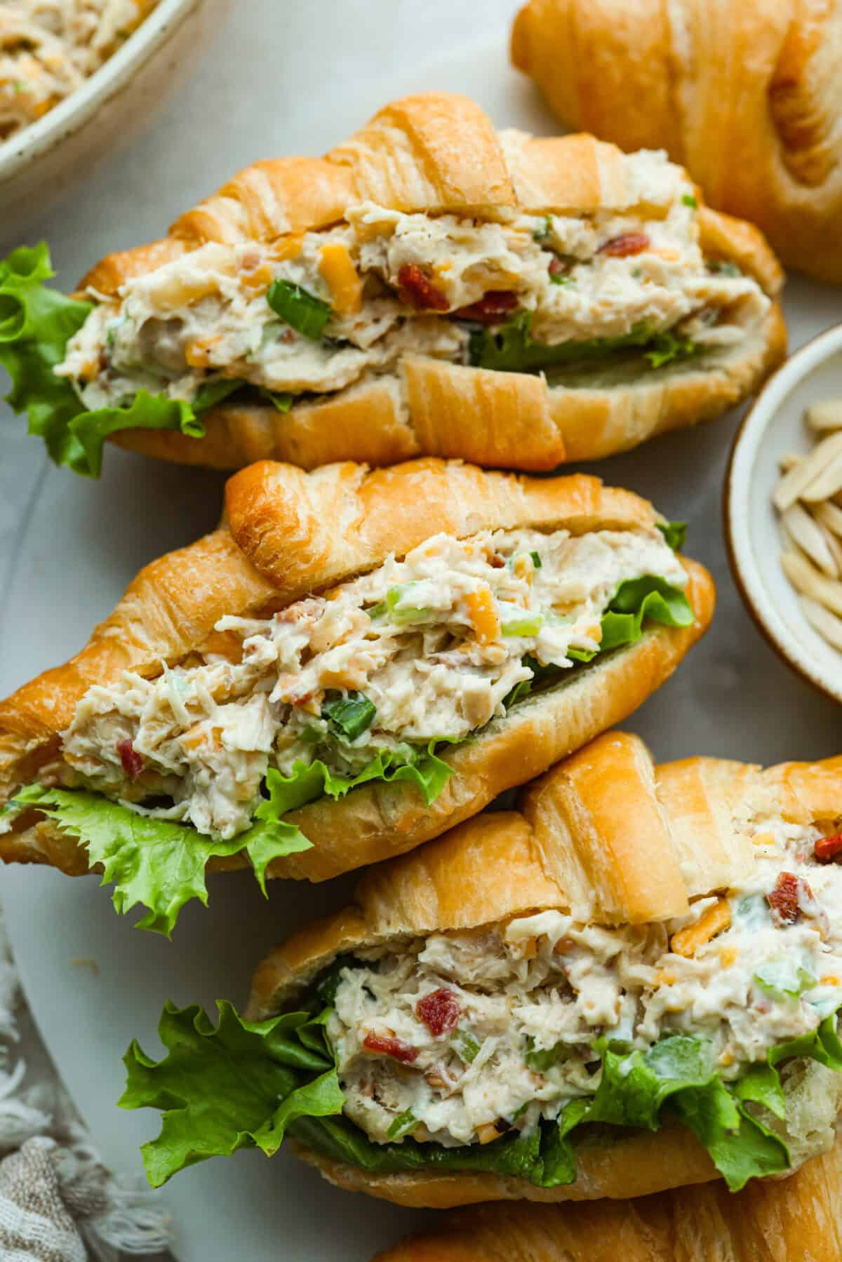 Million dollar chicken salad totally lives up to the name. It’s creamy, cheesy, crunchy, and packed with bacon, so every bite is full of flavor. Serve it on croissants, with crackers, or straight from the bowl! It's that good. Croissants loaded with delicious million dollar chicken salad.