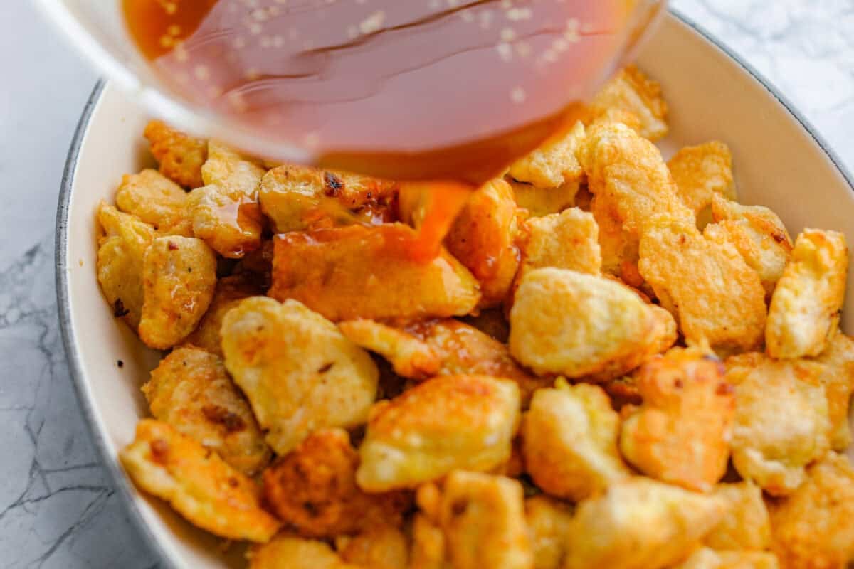 Sauce being poured over the chicken 