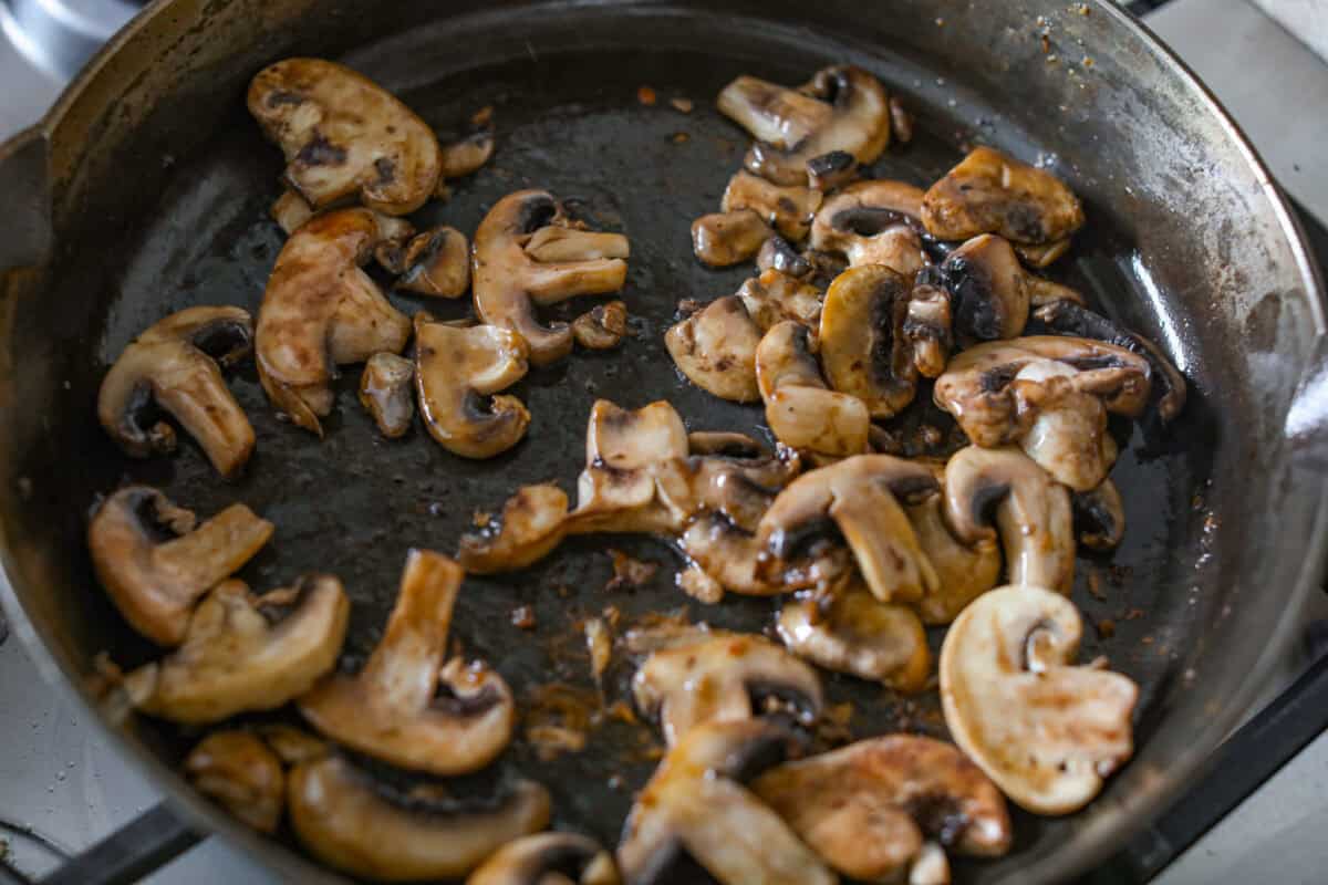 If cozy dinners are your thing, this creamy bacon mushroom thyme chicken needs to happen soon. Between the crispy chicken skin, smoky bacon, and creamy mushroom sauce, every bite tastes rich and savory. Perfect for spooning over mashed potatoes! Mushrooms cooking in olive oil in a skillet.