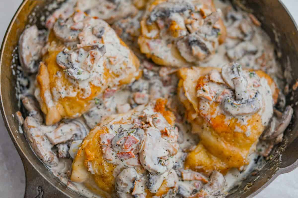 If cozy dinners are your thing, this creamy bacon mushroom thyme chicken needs to happen soon. Between the crispy chicken skin, smoky bacon, and creamy mushroom sauce, every bite tastes rich and savory. Perfect for spooning over mashed potatoes! Chicken thighs added back to the skillet with the mushroom gravy sauce.