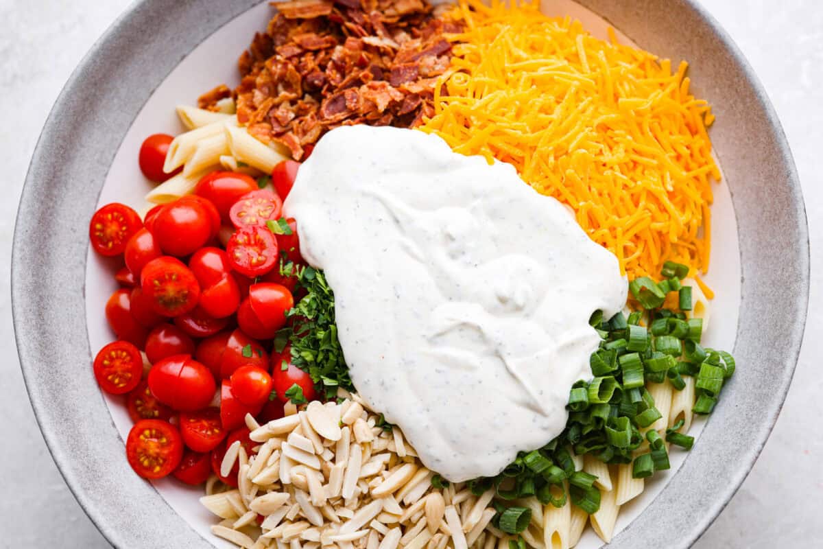 Dressing added to the top of the salad ingredients ready to be mixed in.