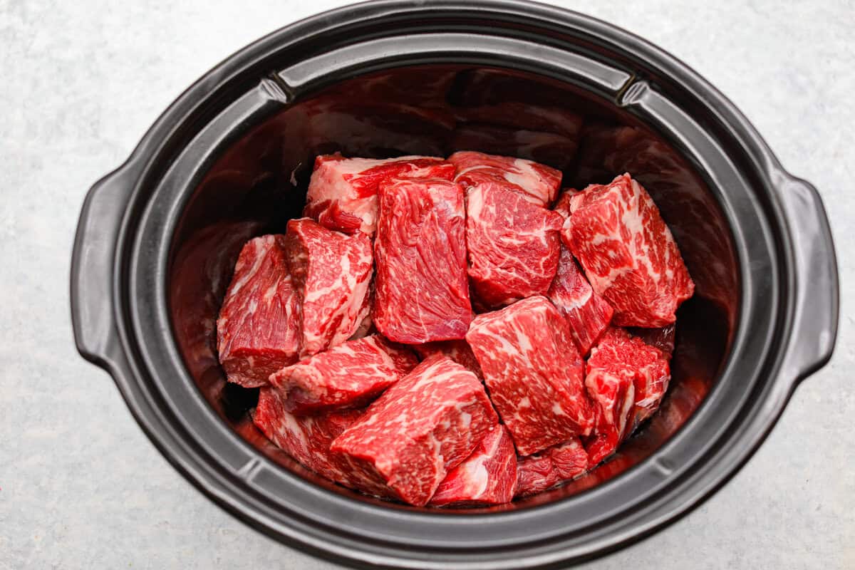 Cook the roast low and slow until tender, j Beef added to a slow cooker.