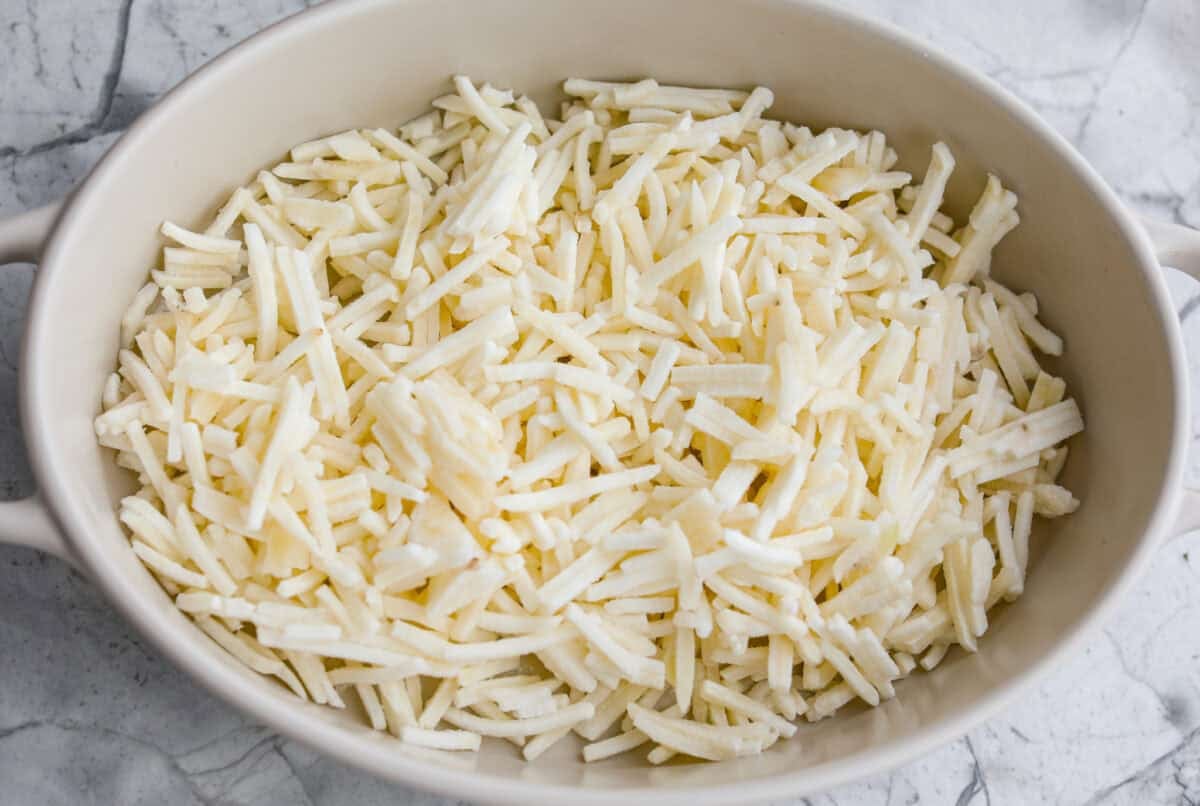 This farmer's casserole is my answer to summer mornings when the kids want cereal again, but I want them to eat something that will actually keep them full. Itโs packed with protein, and it's easy to customize with fresh garden veggies. Hash browns in the bottom of a baking dish.