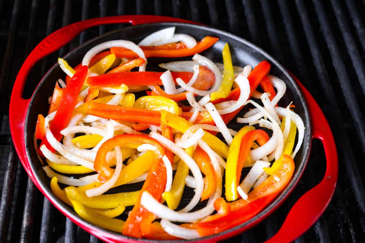 Grilled steak fajitas are one of those dinners that feels fun the second it hit the table. The steak is juicy and smoky, the peppers and onions are tender and flavorful, and everyone gets to build their fajitas just the way they like them. Veggies in a grill pan on the grill.