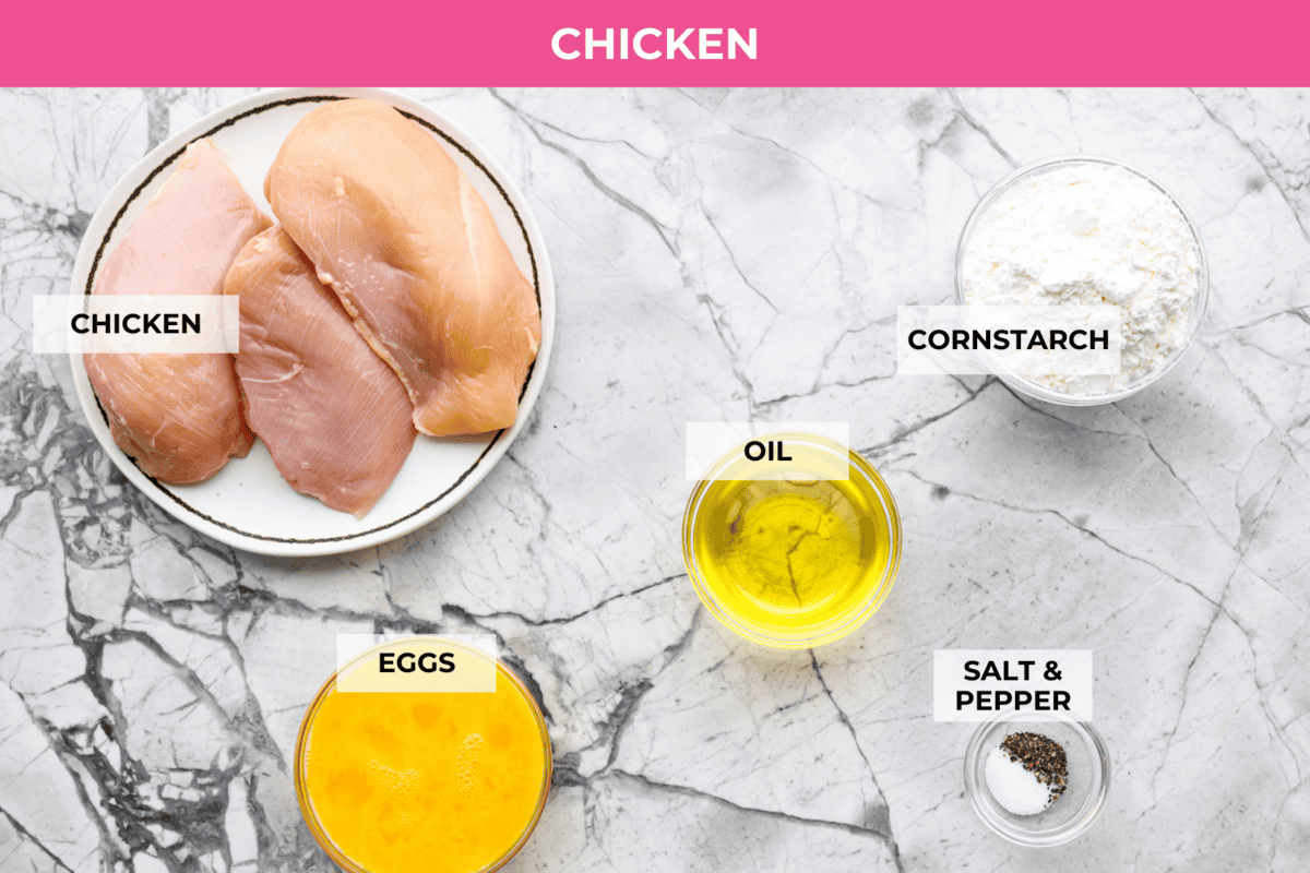 Baked orange chicken is sweet, tangy, and coated in the best sticky orange sauce. It has all the flavor of your favorite takeout, but itโs made right at home and baked until the chicken is perfectly tender. Overhead shot of labeled baked orange chicken ingredients.