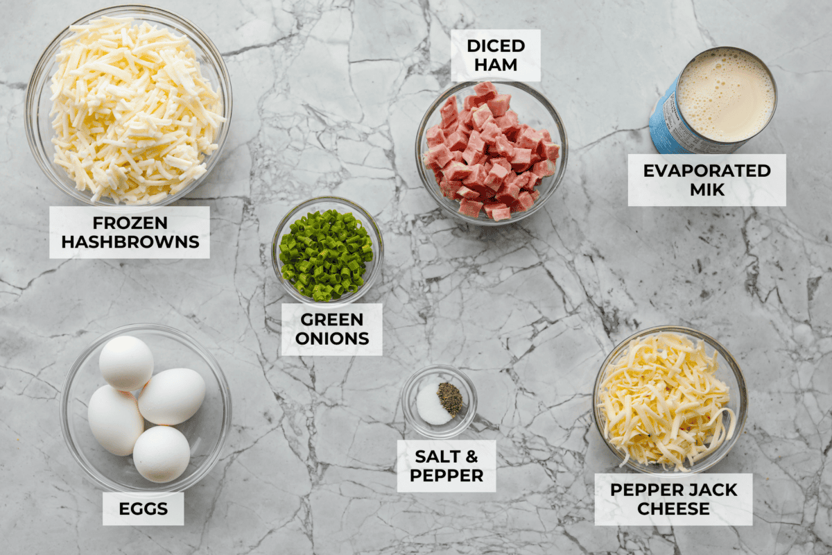 This farmer's casserole is my answer to summer mornings when the kids want cereal again, but I want them to eat something that will actually keep them full. Itโs packed with protein, and it's easy to customize with fresh garden veggies. Overhead shot of labeled farmer's casserole ingredients.