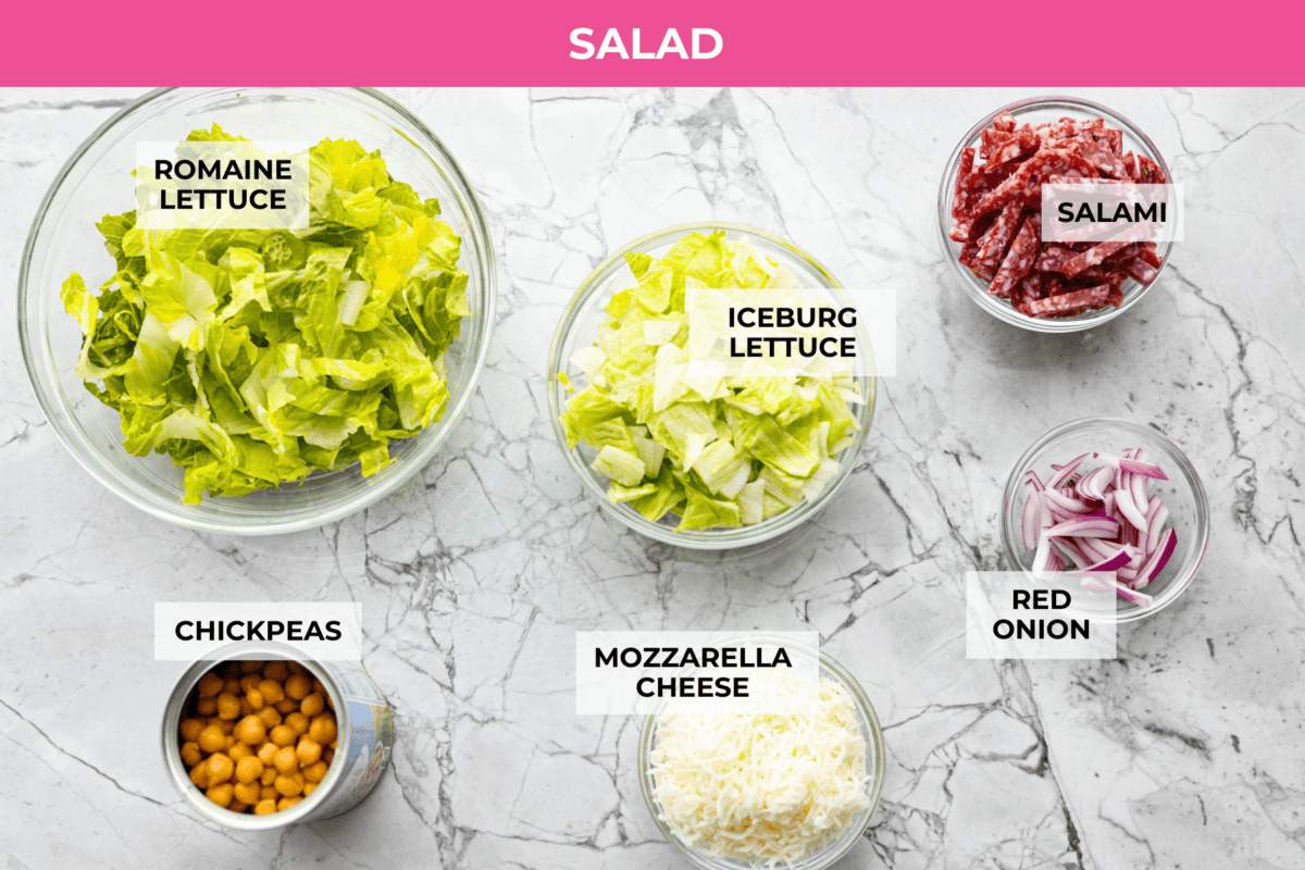 This copycat La Scala Salad is the famous Italian chopped salad from Beverly Hills that Kim Kardashian is rumored to love. Itโs fresh, crunchy, and packed with chickpeas, salami, mozzarella, and zesty red wine vinaigrette. Overhead shot of labeled la scala salad ingredients.