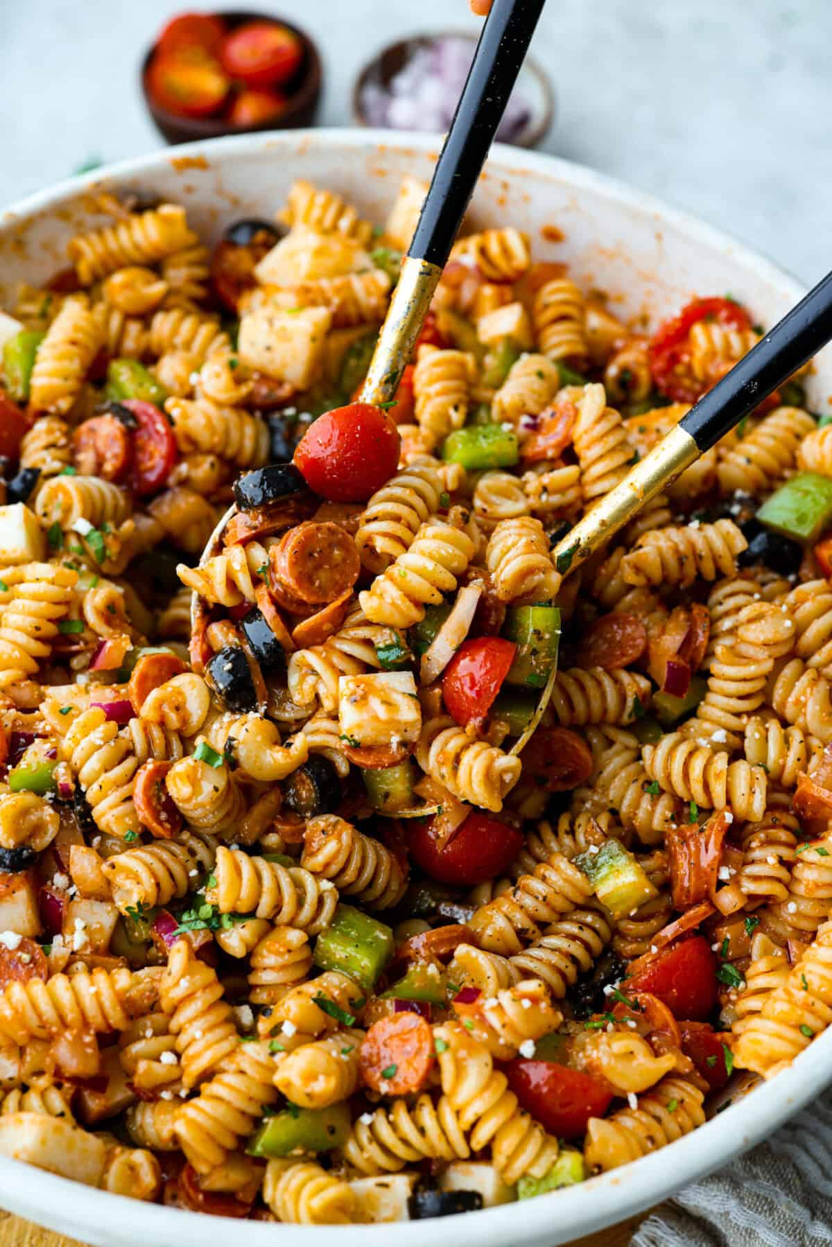 Pizza pasta salad is a fun twist on two family favorites! It's packed with pepperoni, mozzarella, fresh veggies, and a tangy pizza-inspired dressing. Get out of your pasta salad rut and make this unique and incredibly flavorful recipe! Close up shot of the pizza pasta salad.