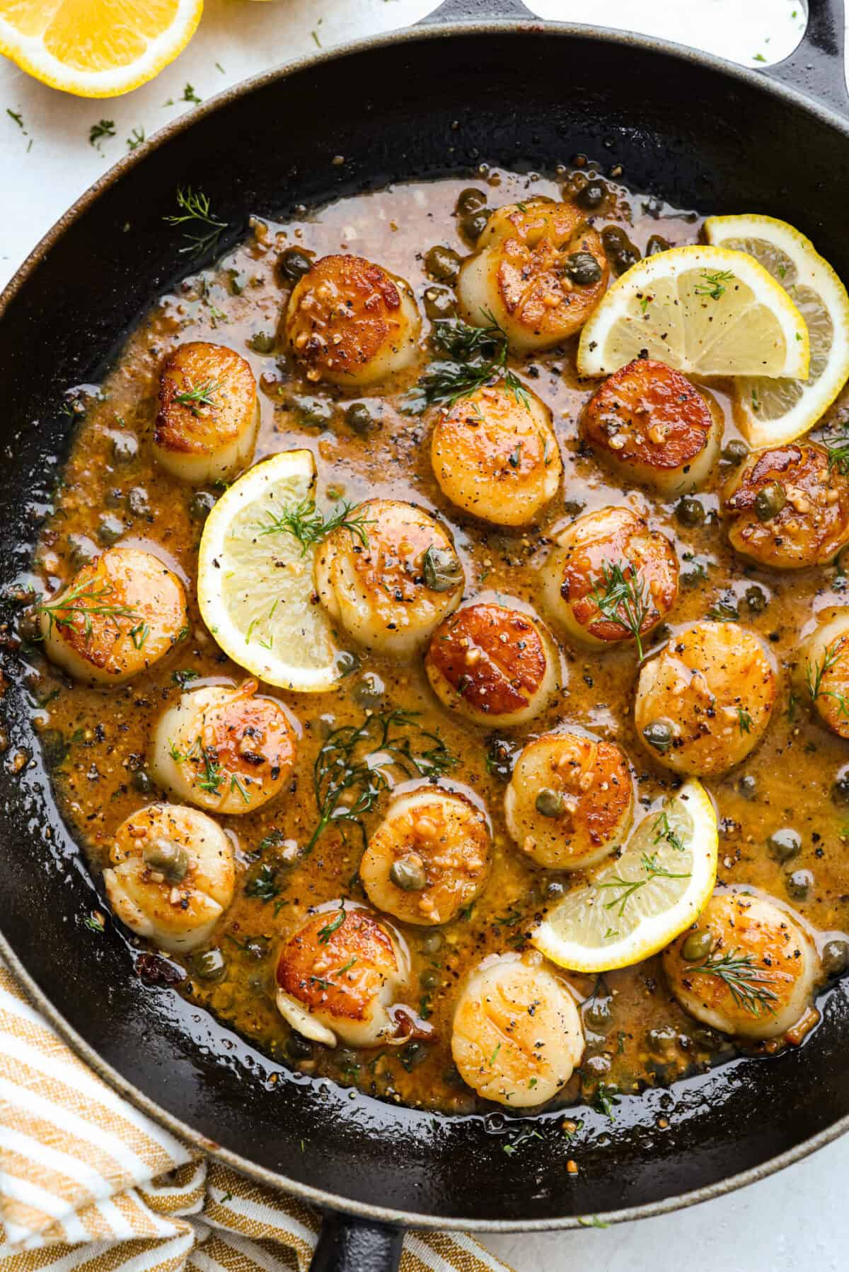 Skillet lemon wedges and pan seared scallops in a caper sauce. 