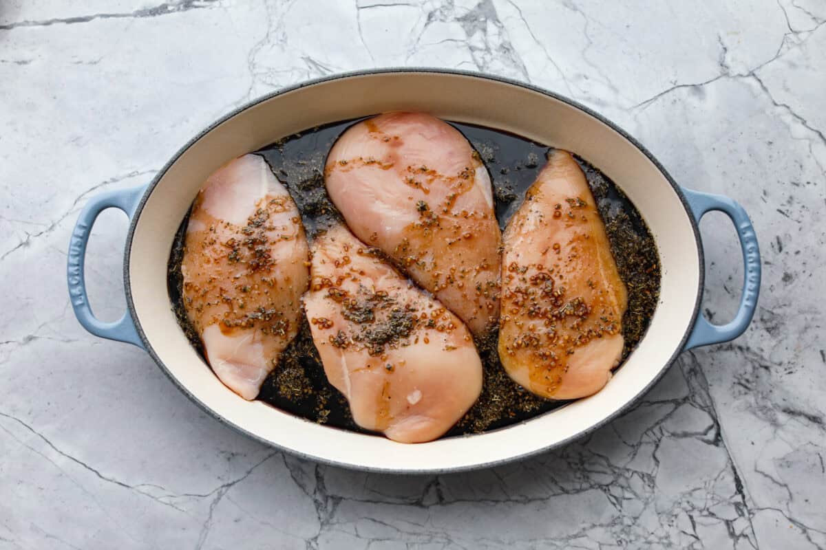 Sauce poured over the toped of the chicken in the pan. 