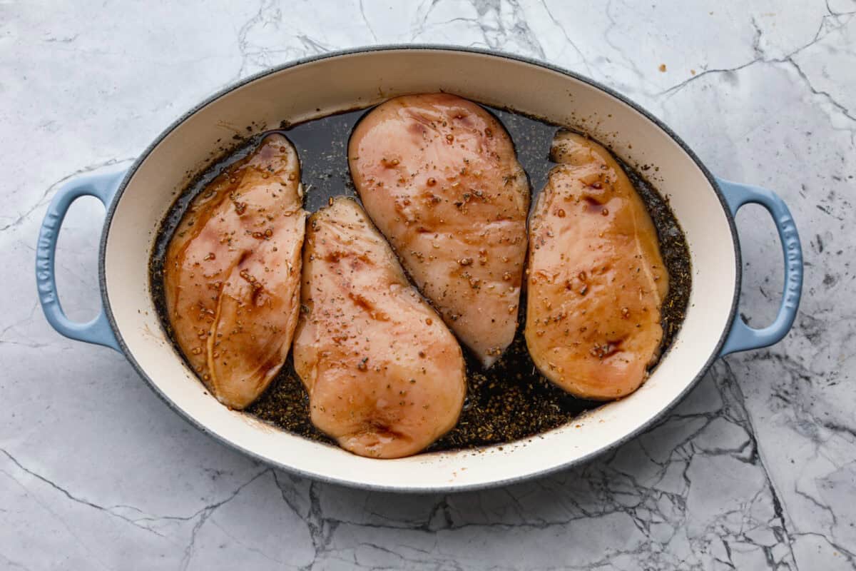 Chicken breasts flipped over to cover them entirely with sauce. 