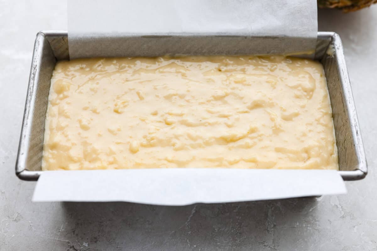 This glazed pineapple bread is what happens when a cozy quick bread meets a tropical vacation. Moist, tender, and drizzled with a sweet pineapple glaze, it's a taste of paradise in every bite. Bread batter in the cake pan.