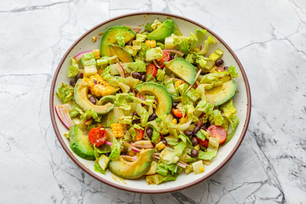 I love salads in the summer, and this grilled shrimp salad is such a good one. It’s fresh, colorful, and filling without feeling heavy. And the dressing? Oh my gosh. The chipotle-lime flavor is so good, you’ll want to pour it on everything. Salad ingredients added to a large serving bowl.
