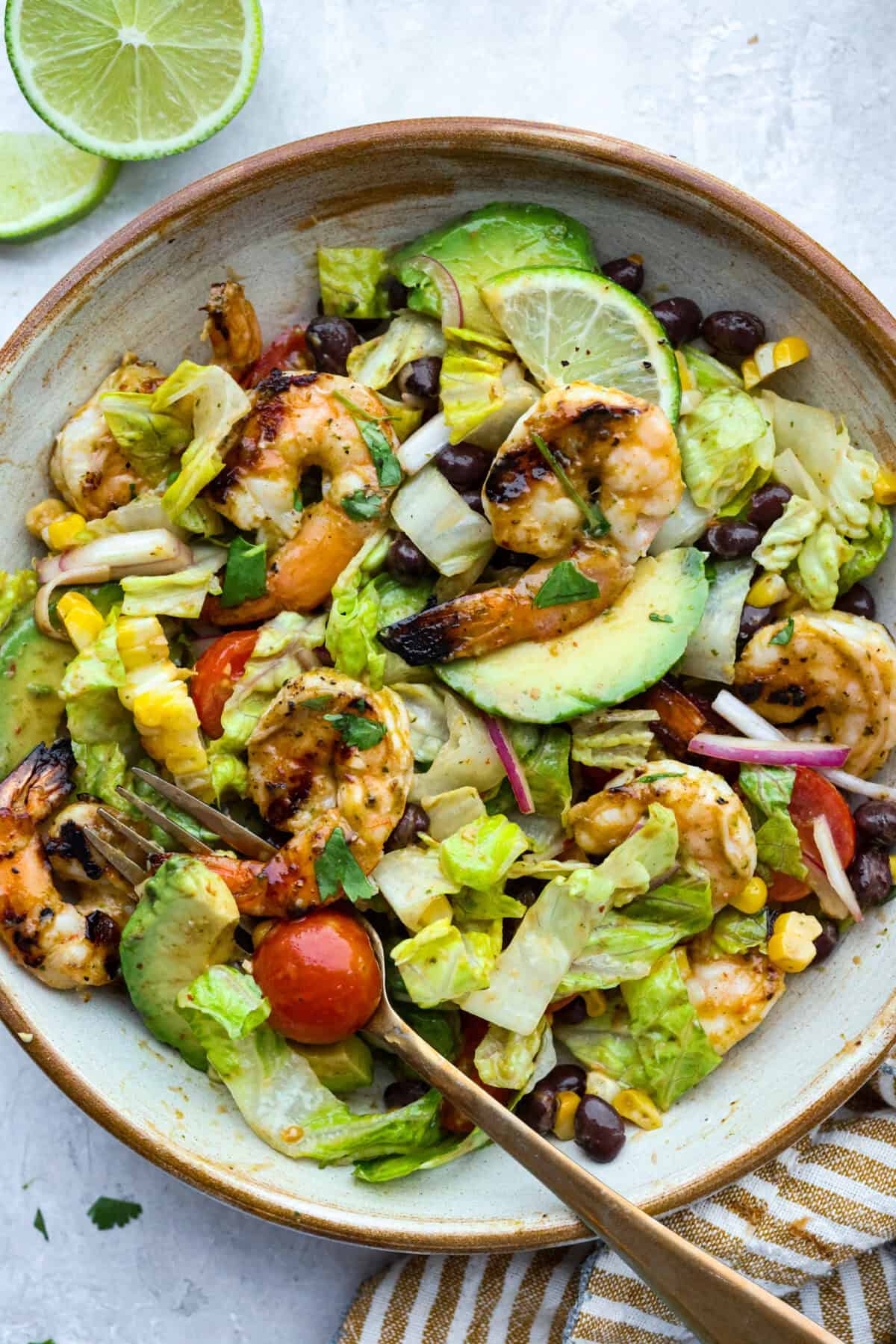 I love salads in the summer, and this grilled shrimp salad is such a good one. It’s fresh, colorful, and filling without feeling heavy. And the dressing? Oh my gosh. The chipotle-lime flavor is so good, you’ll want to pour it on everything. Serving bowl of grilled shrimp salad.