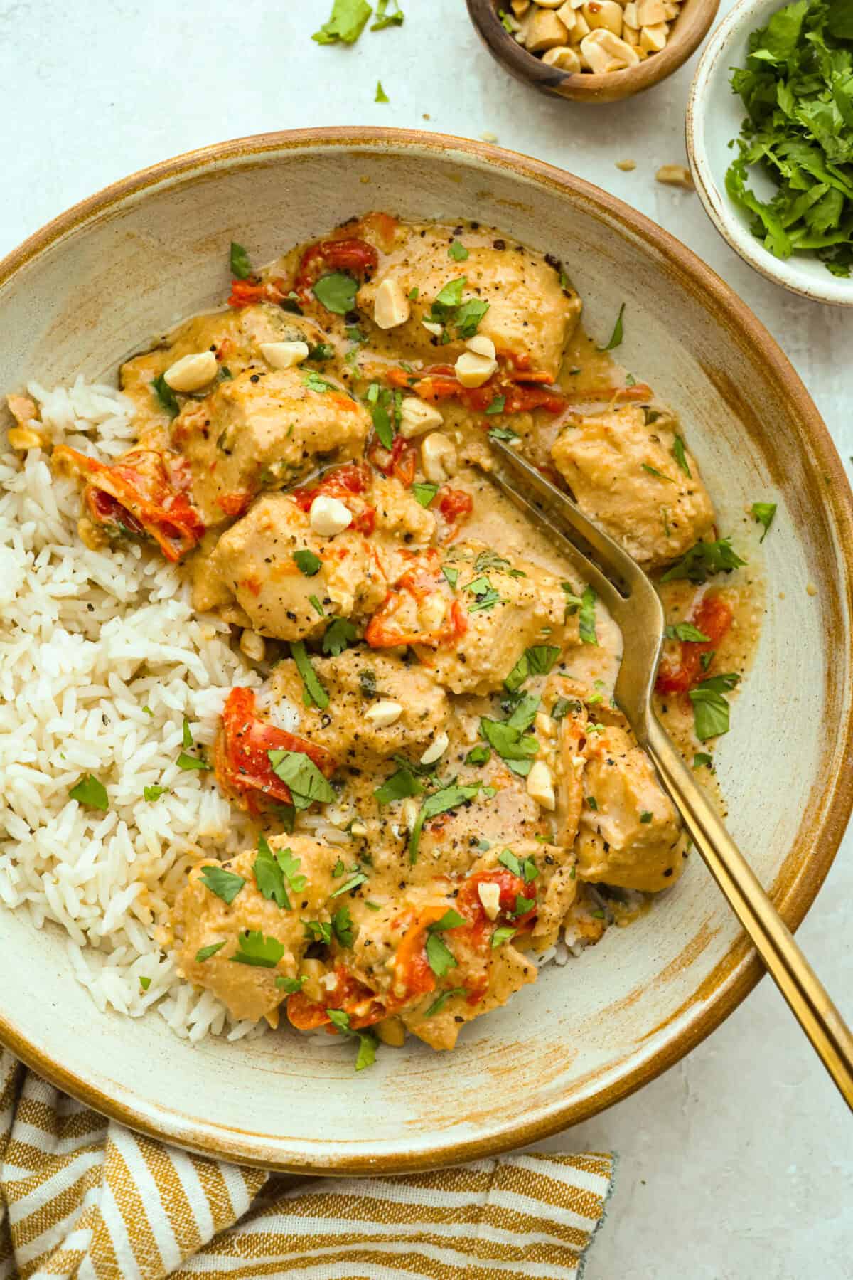 Plate of slow cooker Thai peanut chicken over a bed of rice. 