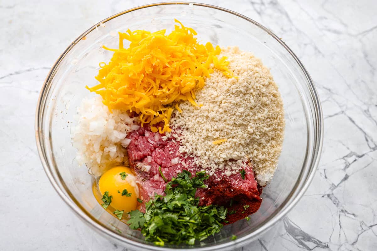 Meatball ingredients all added to a mixing bowl. 