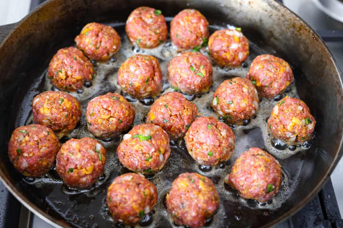 Meatballs cooking in the bacon grease. 