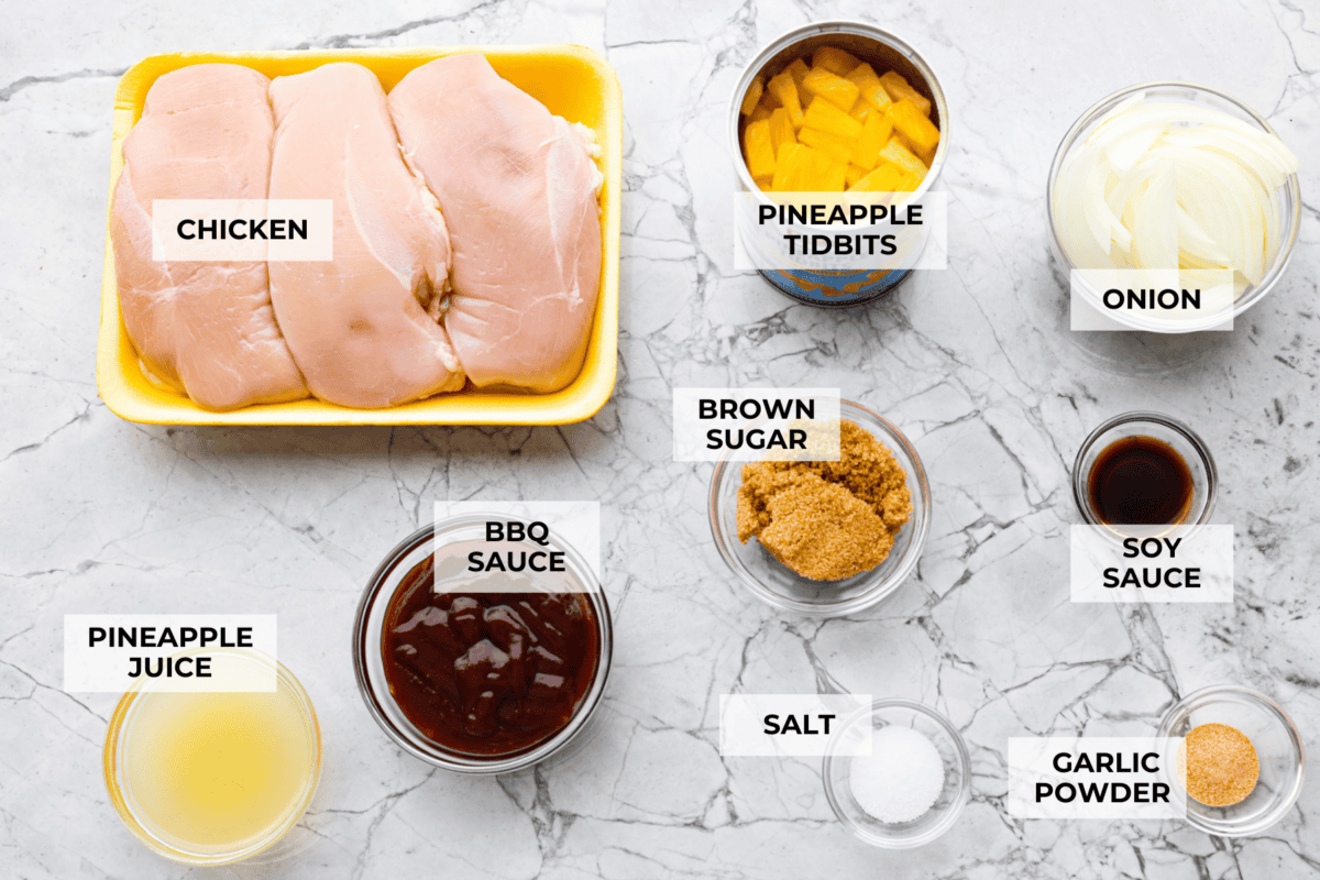 Slow cooker Aloha chicken is sweet, smoky, and so easy to throw together! Tender chicken cooks with pineapple, onion, and barbecue sauce until itβs full of flavor and ready to shred. Serve it over rice for a simple dinner the whole family will love. Overhead shot of labeled ingredients.