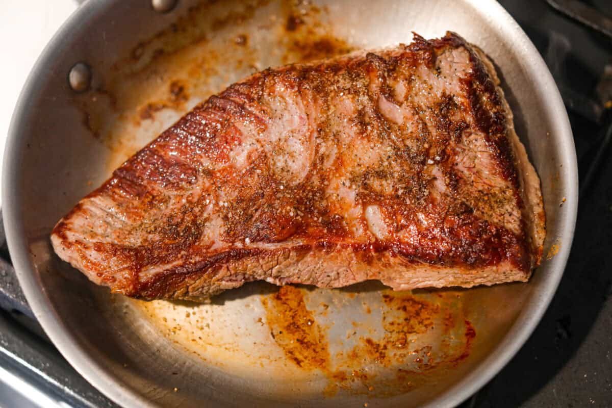 Brisket browning in a skillet.