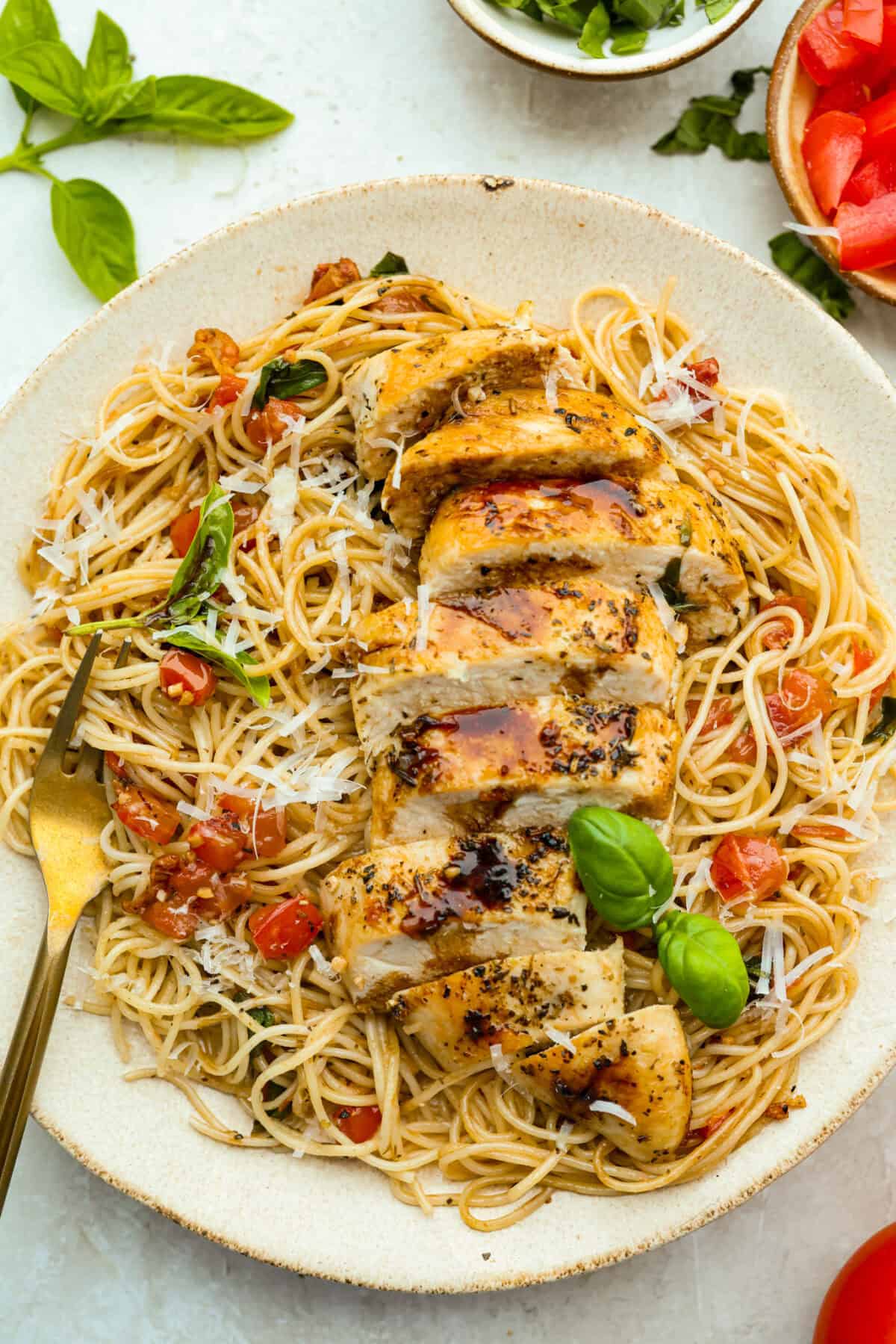 If you have fresh summer tomatoes sitting on your counter, this is your sign to make this Bruschetta Chicken Pasta. It's light, fresh, and shows that simple ingredients can make the best meals. Plated bruschetta chicken pasta.