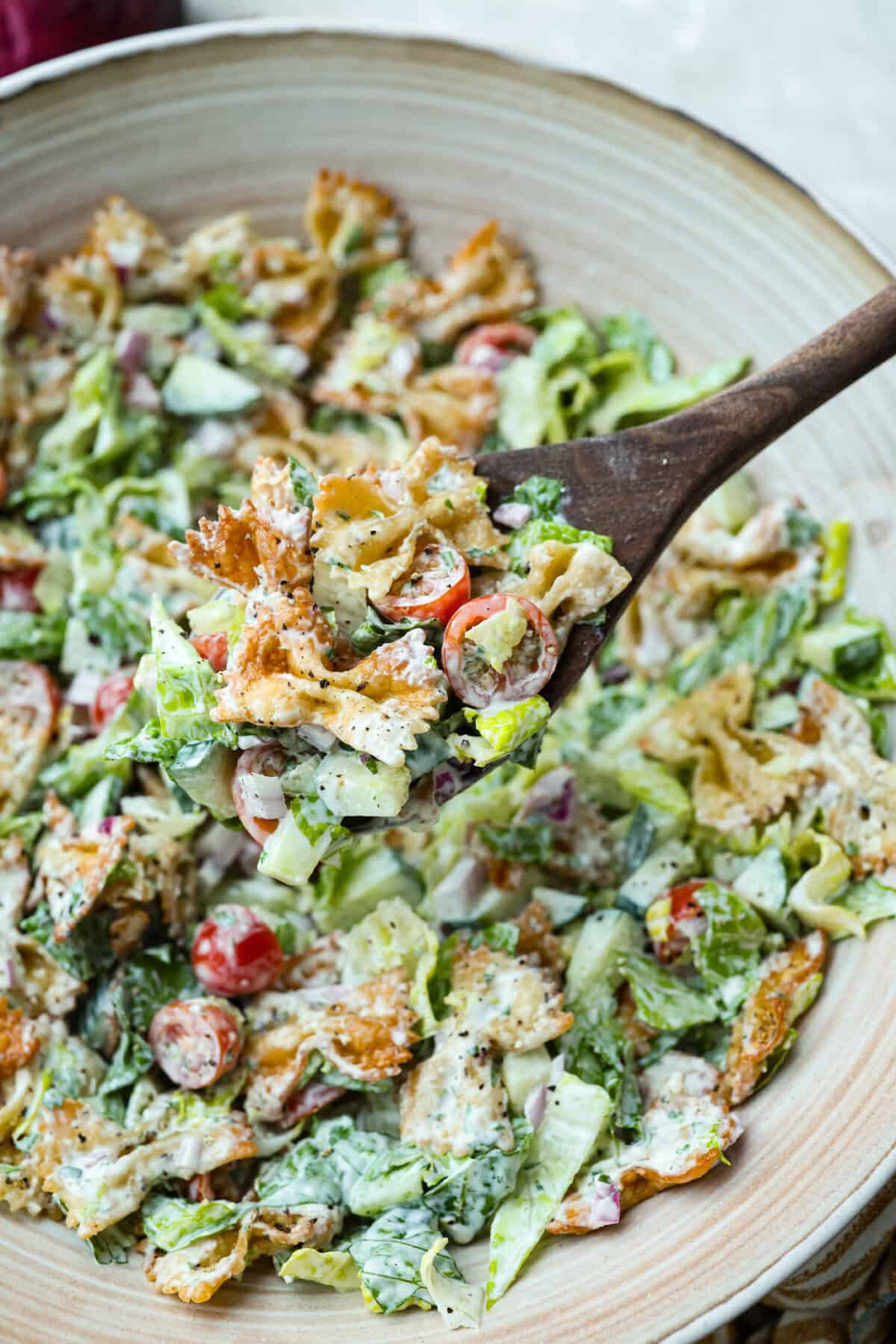 The viral crispy pasta salad trend is here, and it’s easy to see what the hype is about! Golden, crunchy pasta is tossed with fresh veggies and a creamy dressing for a fun upgrade that’s anything but boring. Large spoon lifting a scoop of crispy pasta salad out of the large serving bowl.