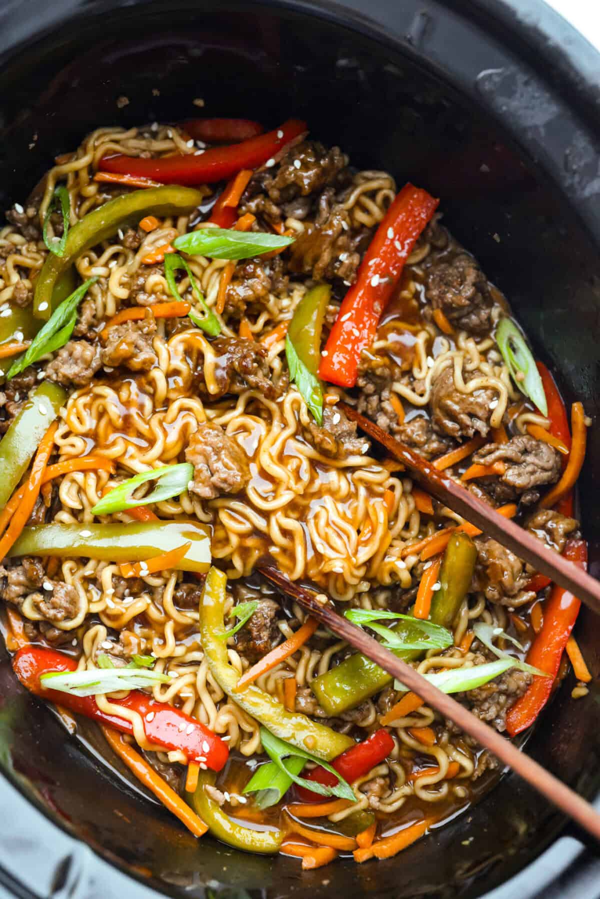 Slow cooker ramen gives you all the slurpy, saucy noodle bowl flavor with almost no effort. The veggies and beef slow cook in just an hour, then the ramen noodles go in for a quick 10 minutes. No hot oven, no boiling pots! Overhead shot of slow cooker ramen.