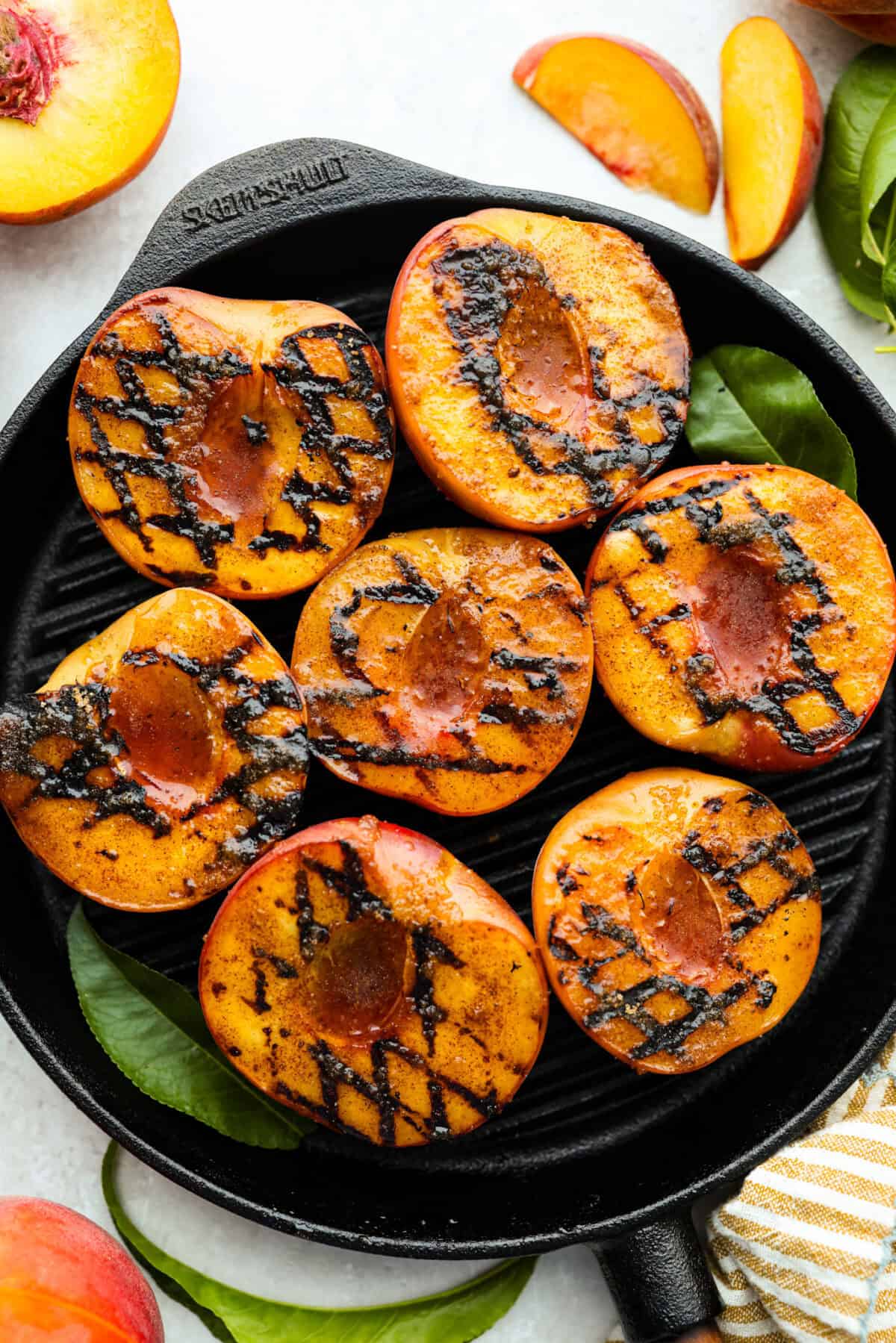 Grilled peaches with grill marks on a grilling pan. 