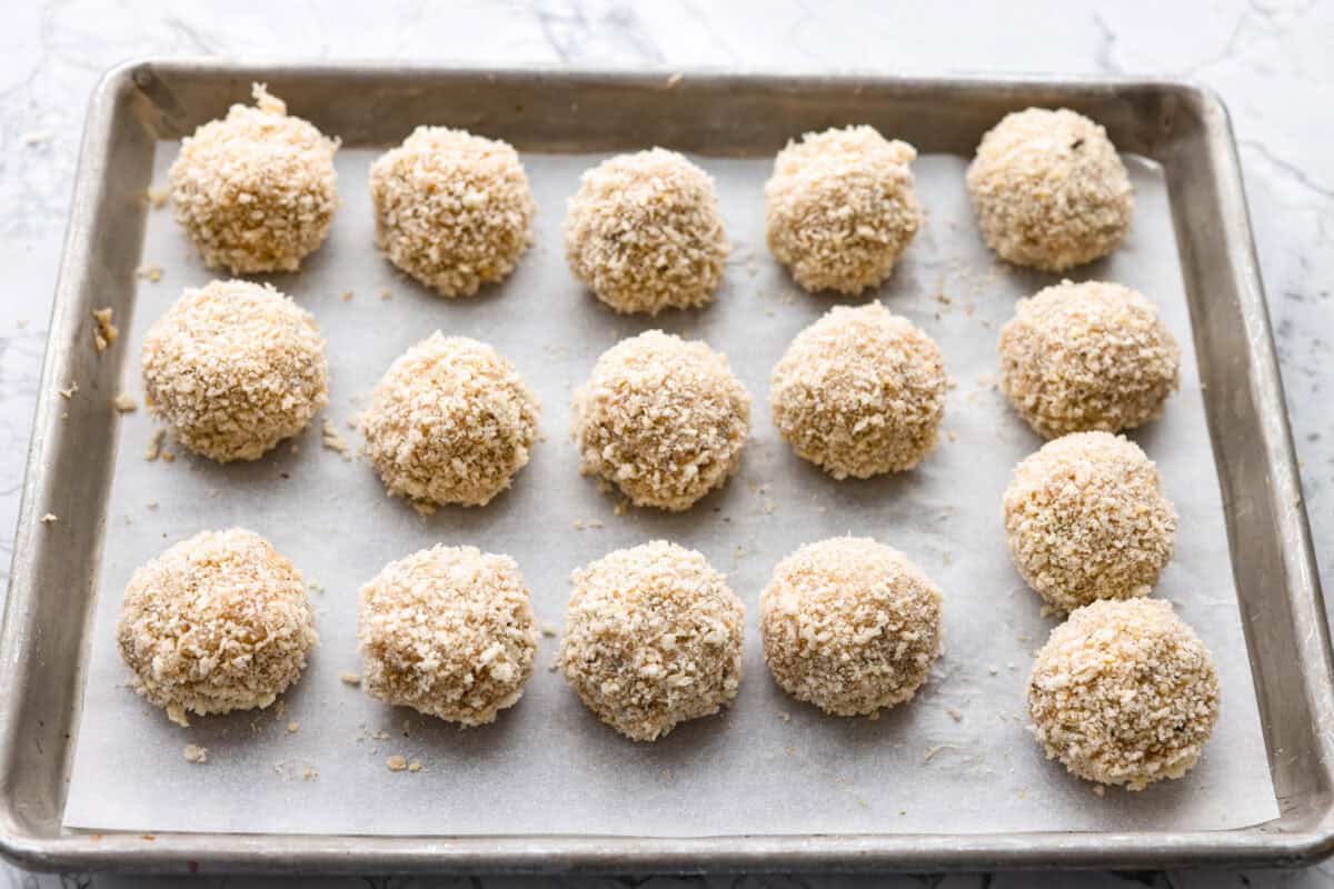 Meatballs formed and coated in the breadcrumb and parmesan mixture. 