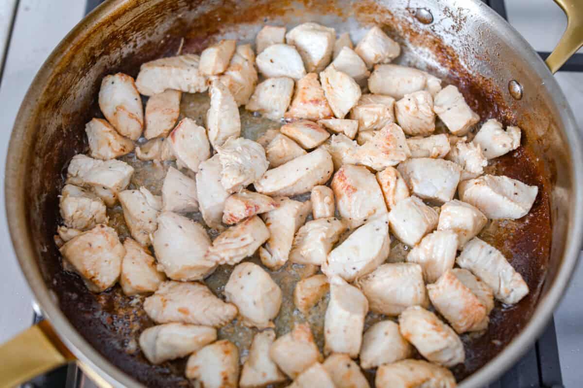 chicken cooking in a skillet.
