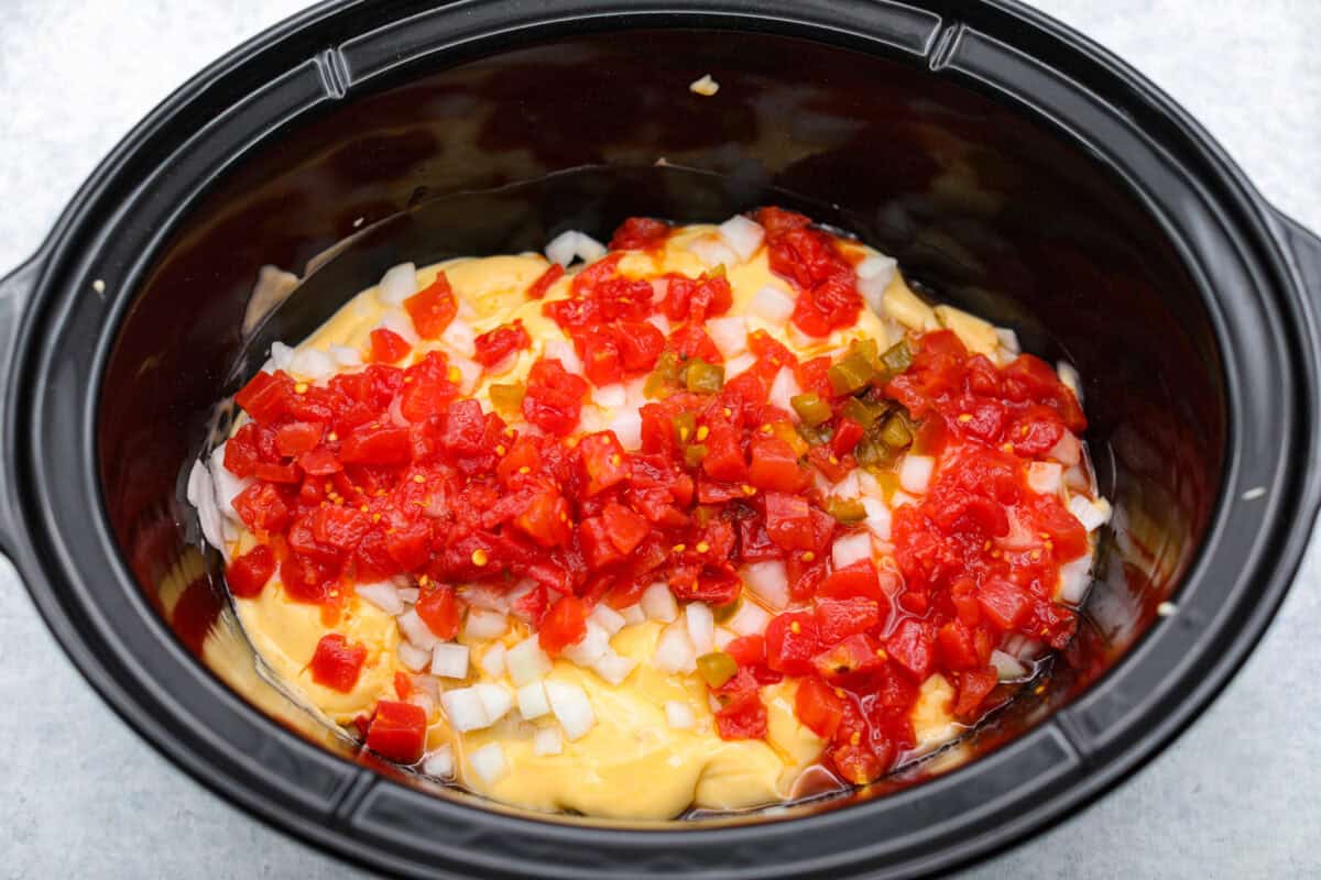 This crockpot chicken spaghetti will have everyone running to the dinner table! The slow cooker does the work while the chicken becomes tender and flavorful, then it's tossed with spaghetti, melty cheese, and a creamy sauce. Sauce ingredients added to the crockpot.